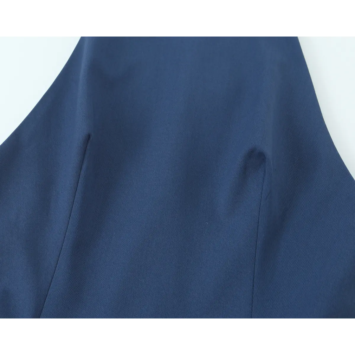 Close-up detail of the structured fitted bodice and vertical seams on a navy blue halter-neck mini dress.