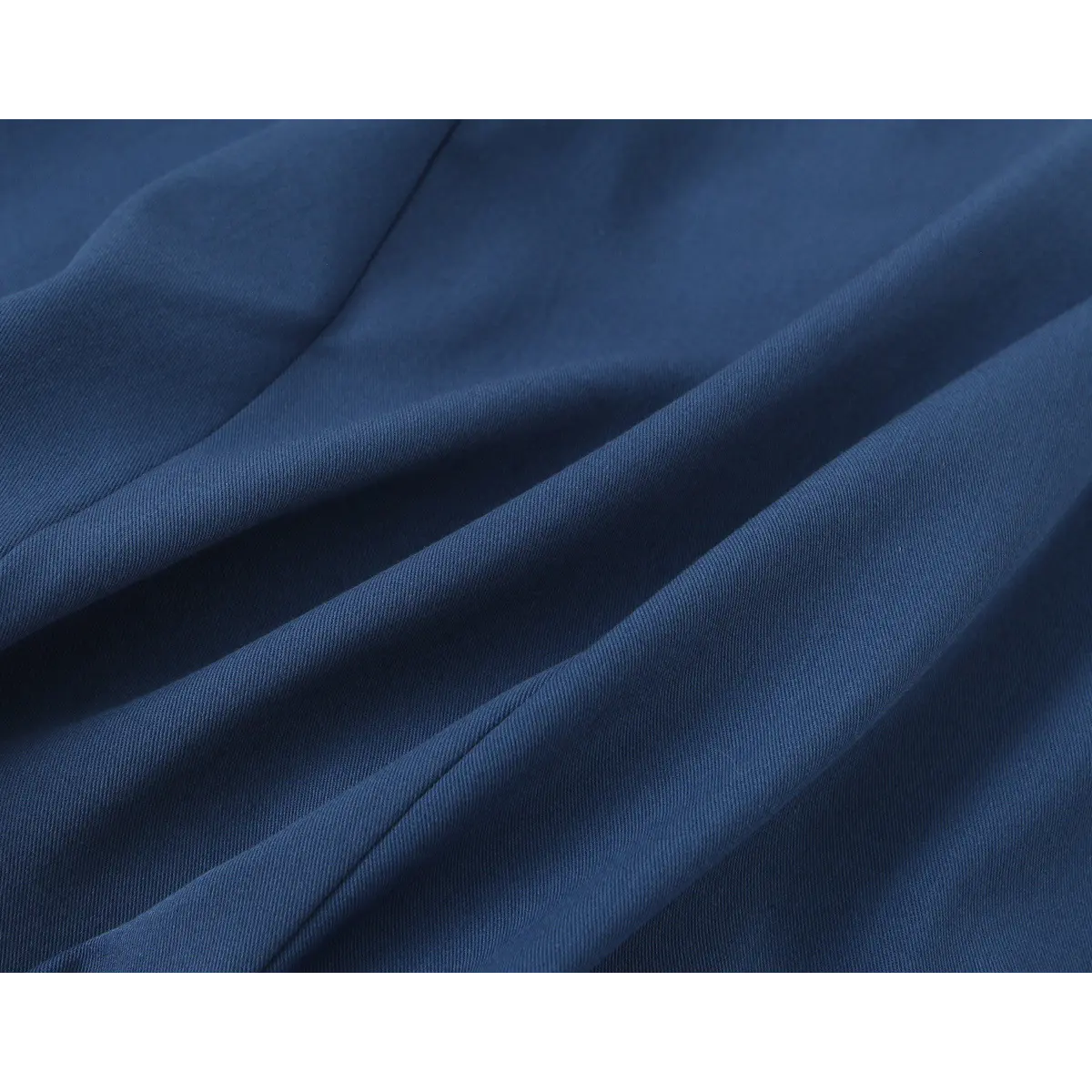 Close-up detail of the smooth, drapey fabric texture and seam construction on a navy blue halter-neck mini dress.