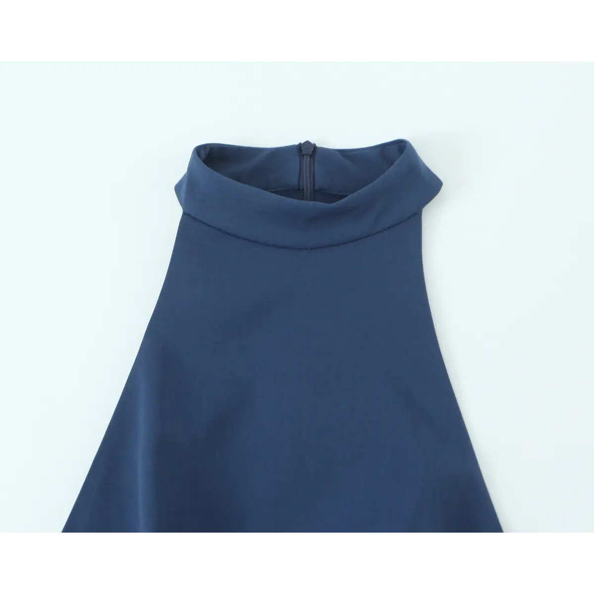 Close-up detail of the high halter neckline and back zipper on a navy blue mini dress.