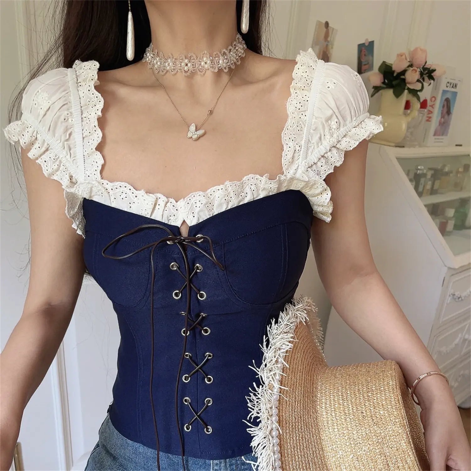 Front view lifestyle shot of the navy blue lace-trimmed corset-style top