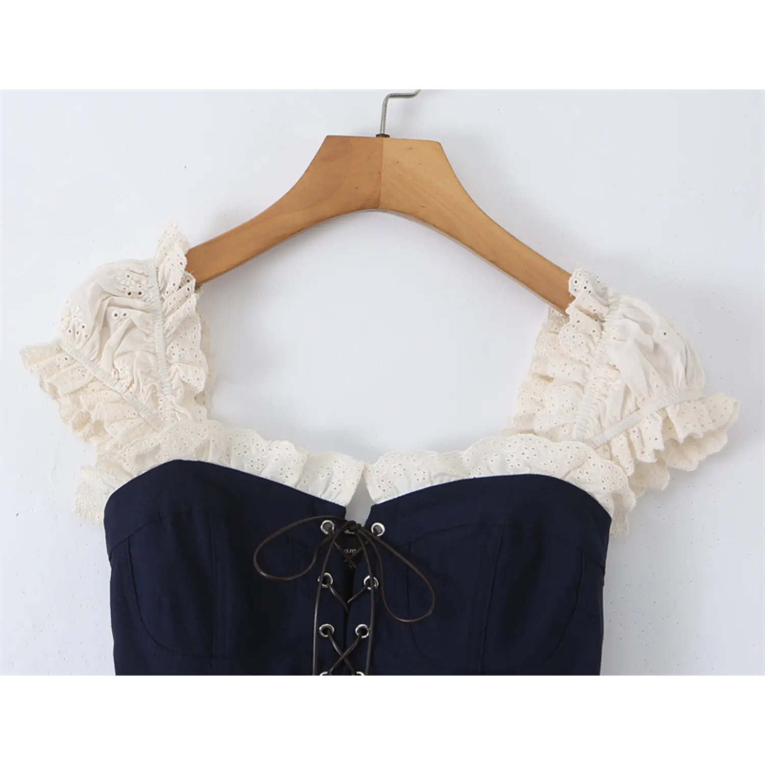 lose-up of the lace trim and puff sleeve details on the navy blue corset-style top