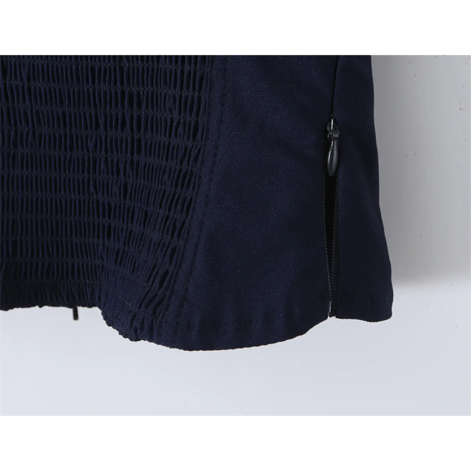 Close-up of the side zipper closure on the navy blue lace-trimmed corset-style top