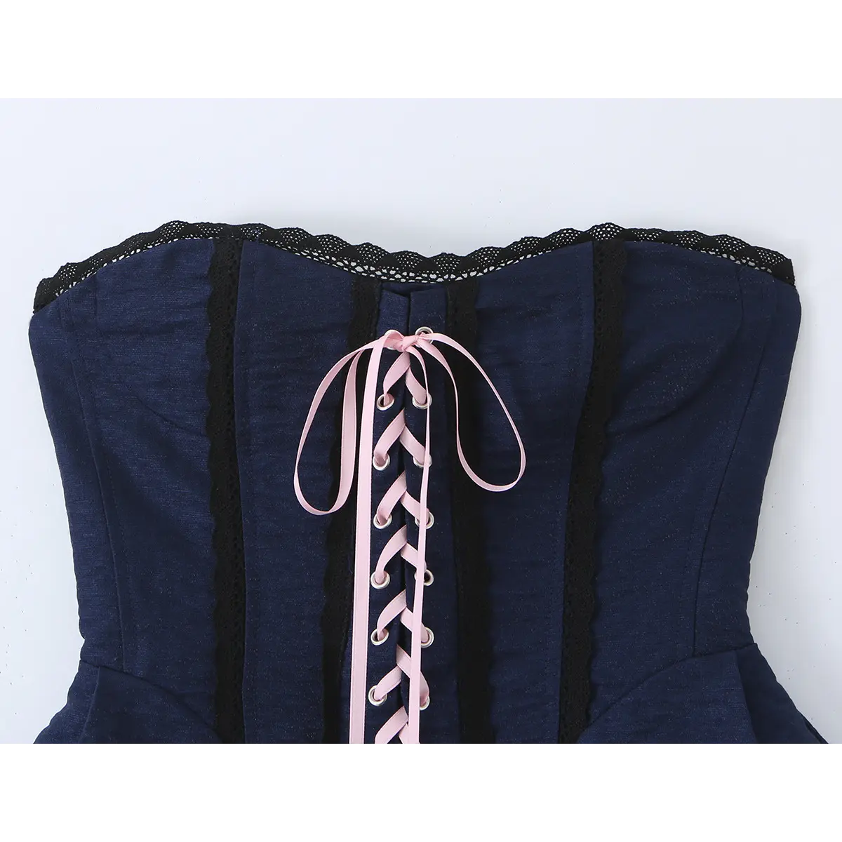 Close-up of the front lace-up closure with pink ribbon and eyelets.