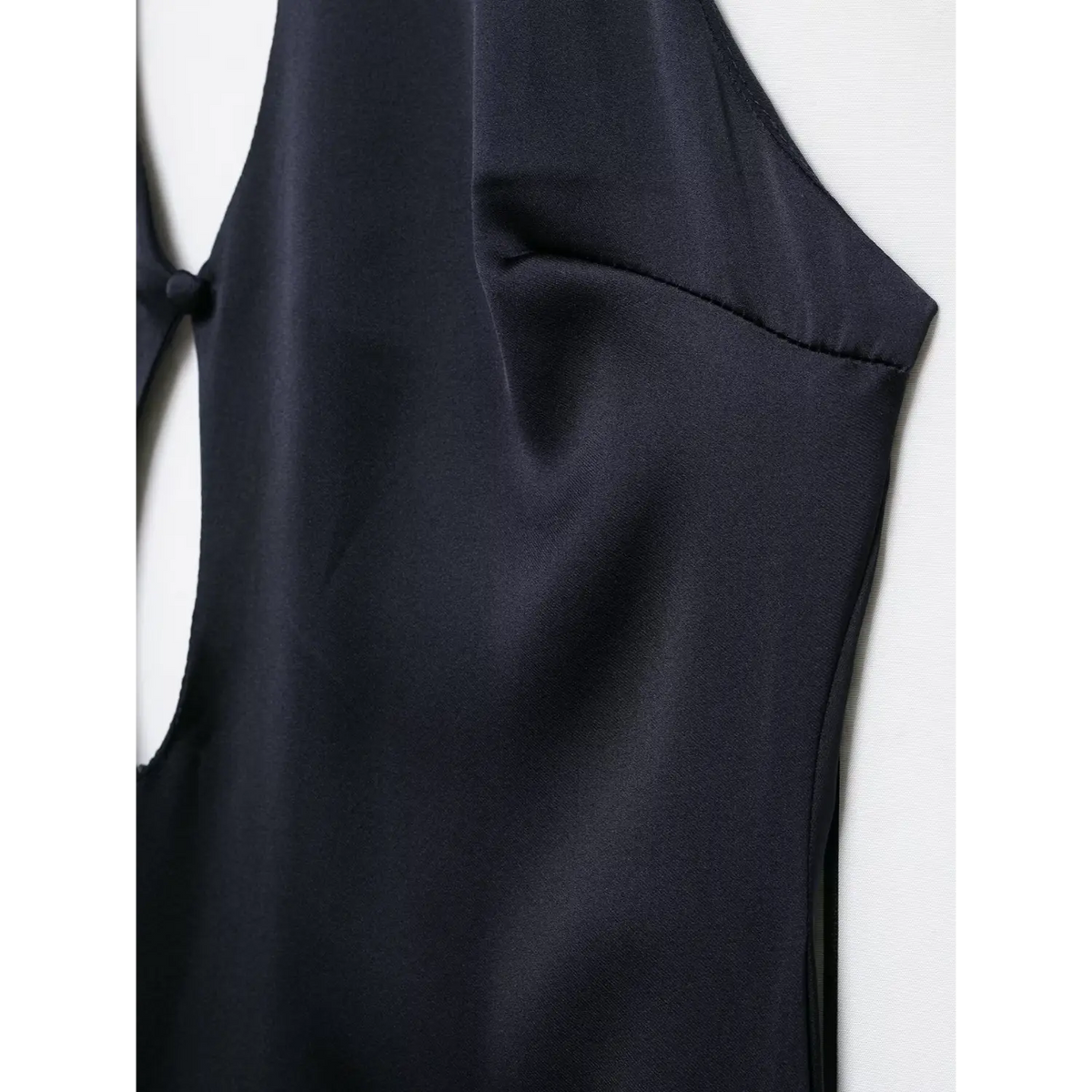 Close-up of armhole seam on navy blue satin dress