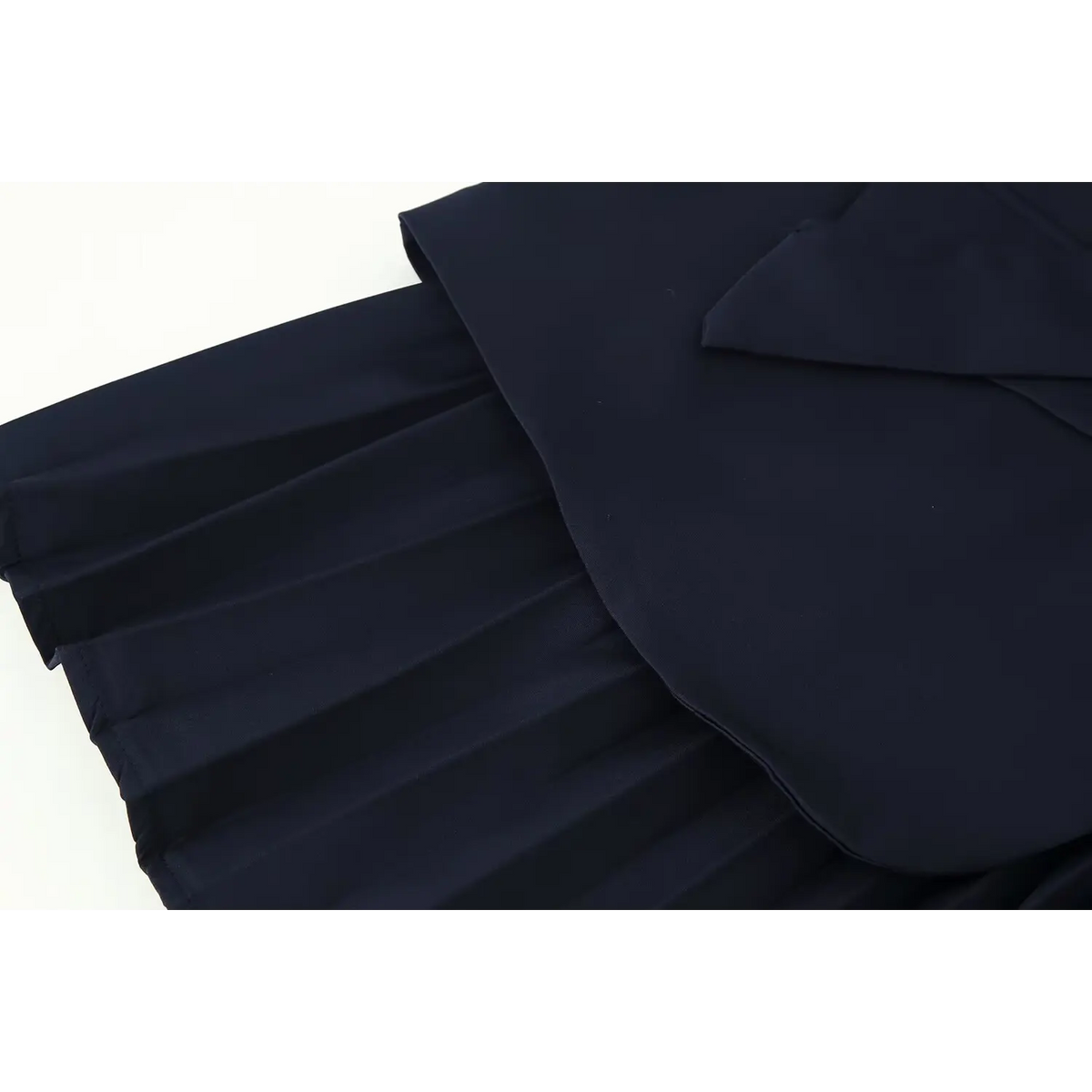 Close-up of pleated skirt and asymmetric peplum hem