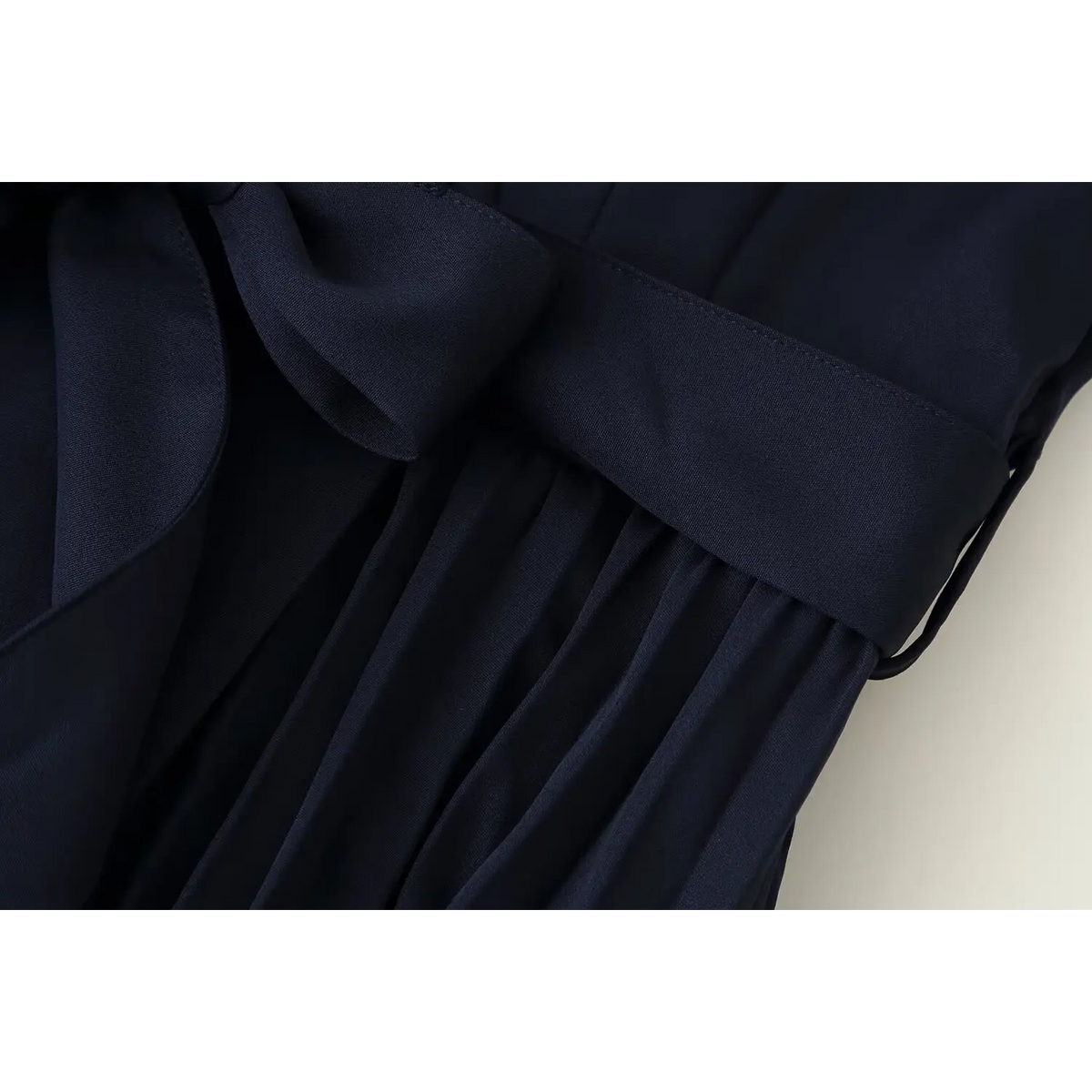 Close-up of belt and pleated skirt junction