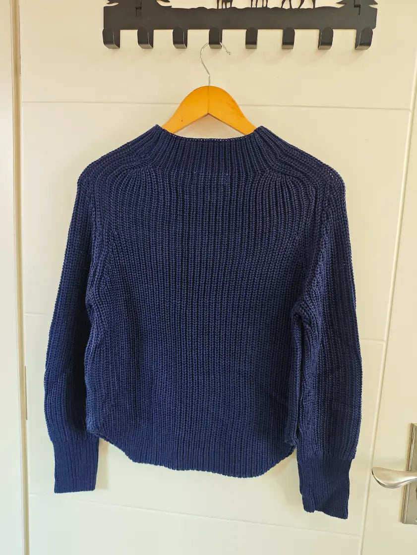 Navy chunky ribbed mock neck balloon sleeve sweater hanging on door, back view