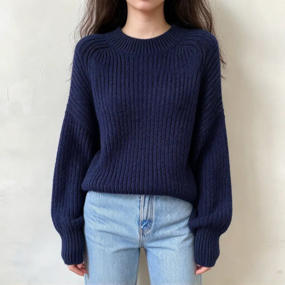 Model wearing navy chunky ribbed mock neck balloon sleeve sweater with jeans, front view