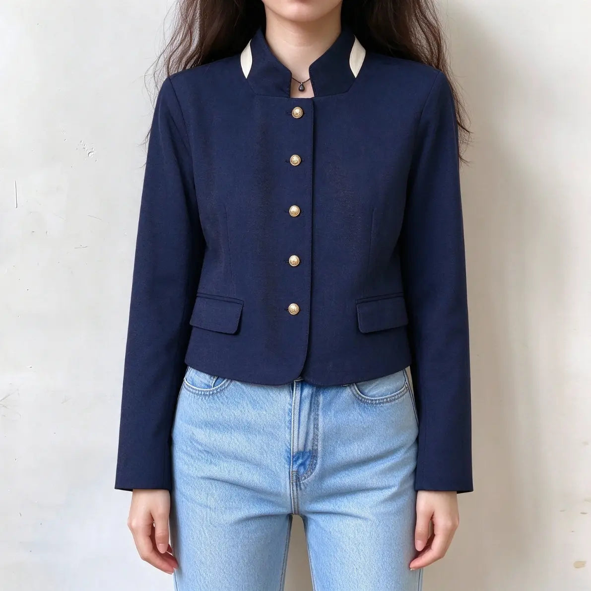 Model wearing navy contrast trim gold button stand collar cropped jacket with jeans, front view
