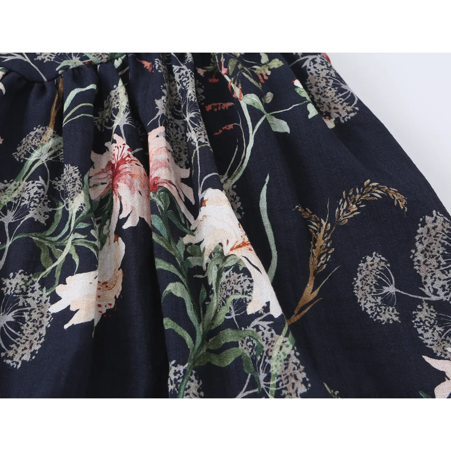Close-up of vintage lily floral fabric and skirt gathers on navy blue spaghetti strap mini dress