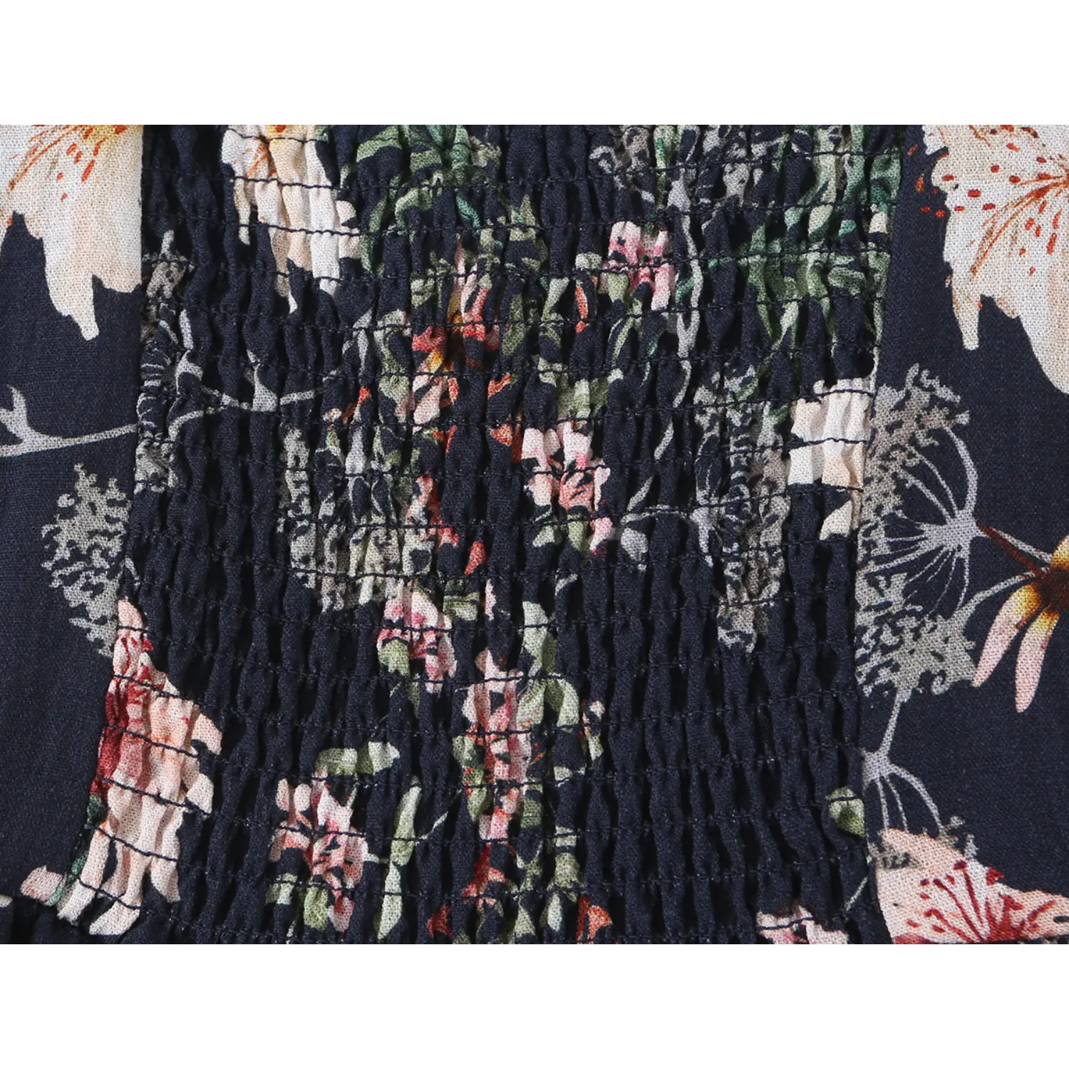 Close-up shot of smocked elasticated back panel on navy blue floral print cami mini dress