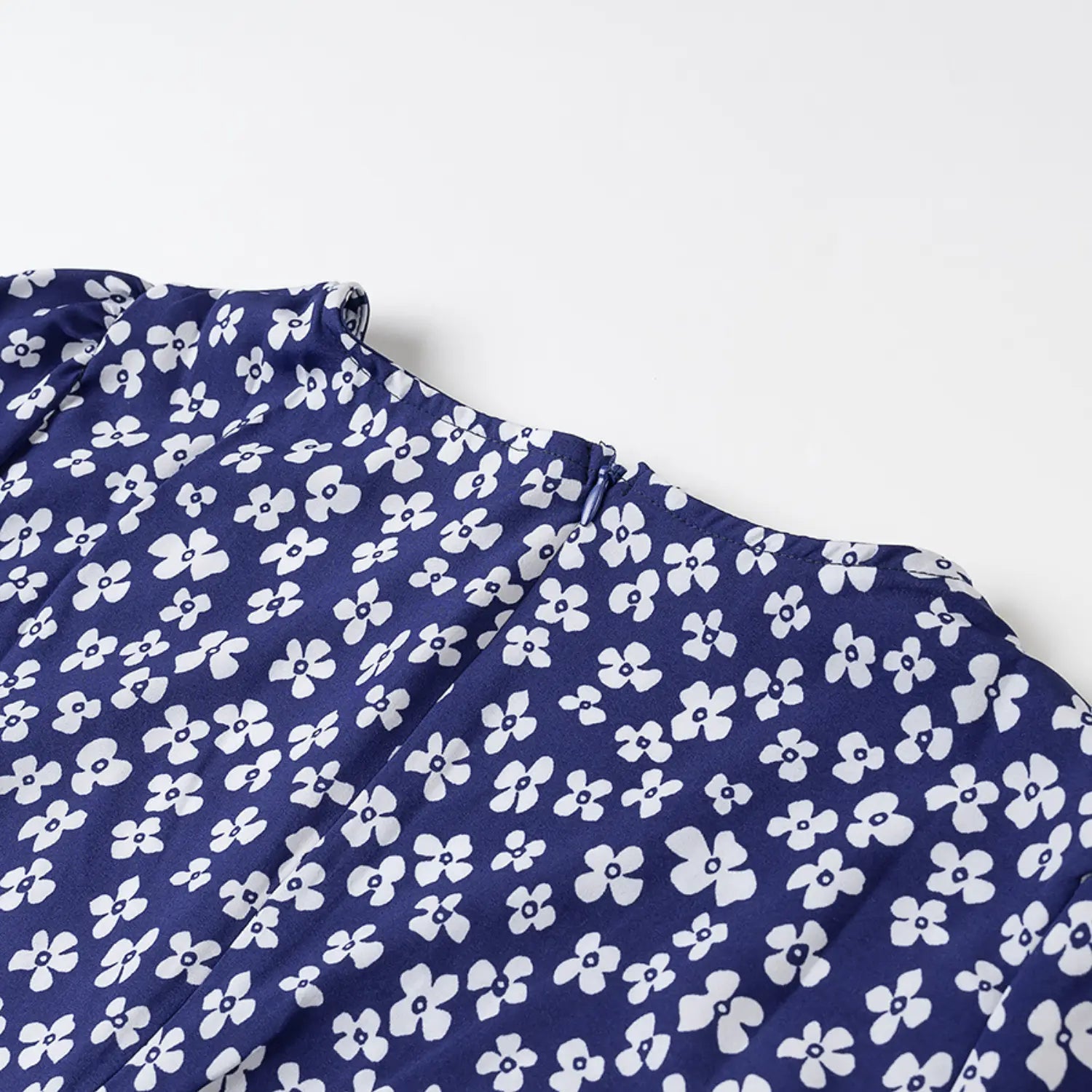 Close-up of the back neckline and invisible zipper on the navy blue floral dress