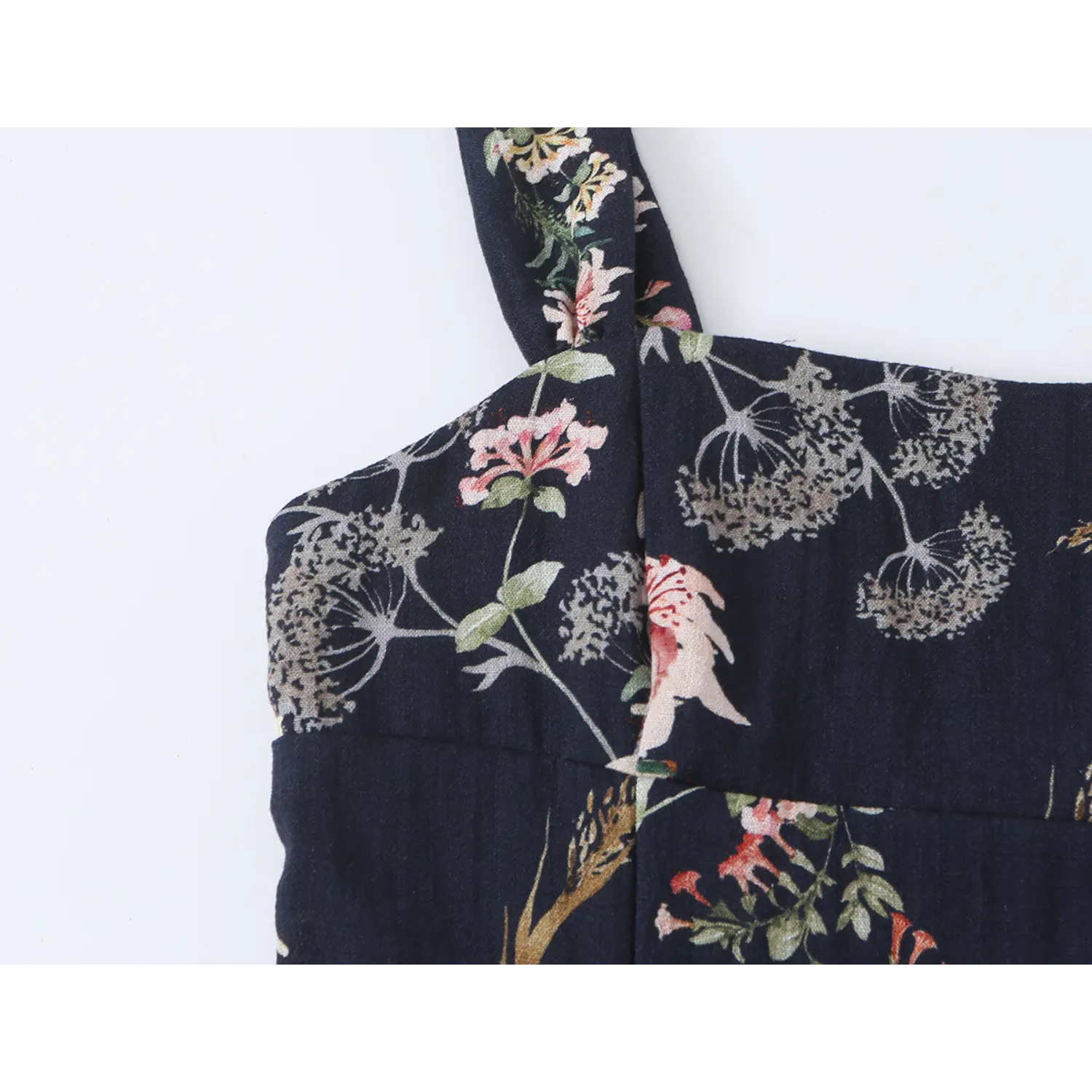 Extreme close-up of vintage lily floral fabric print on navy cami dress