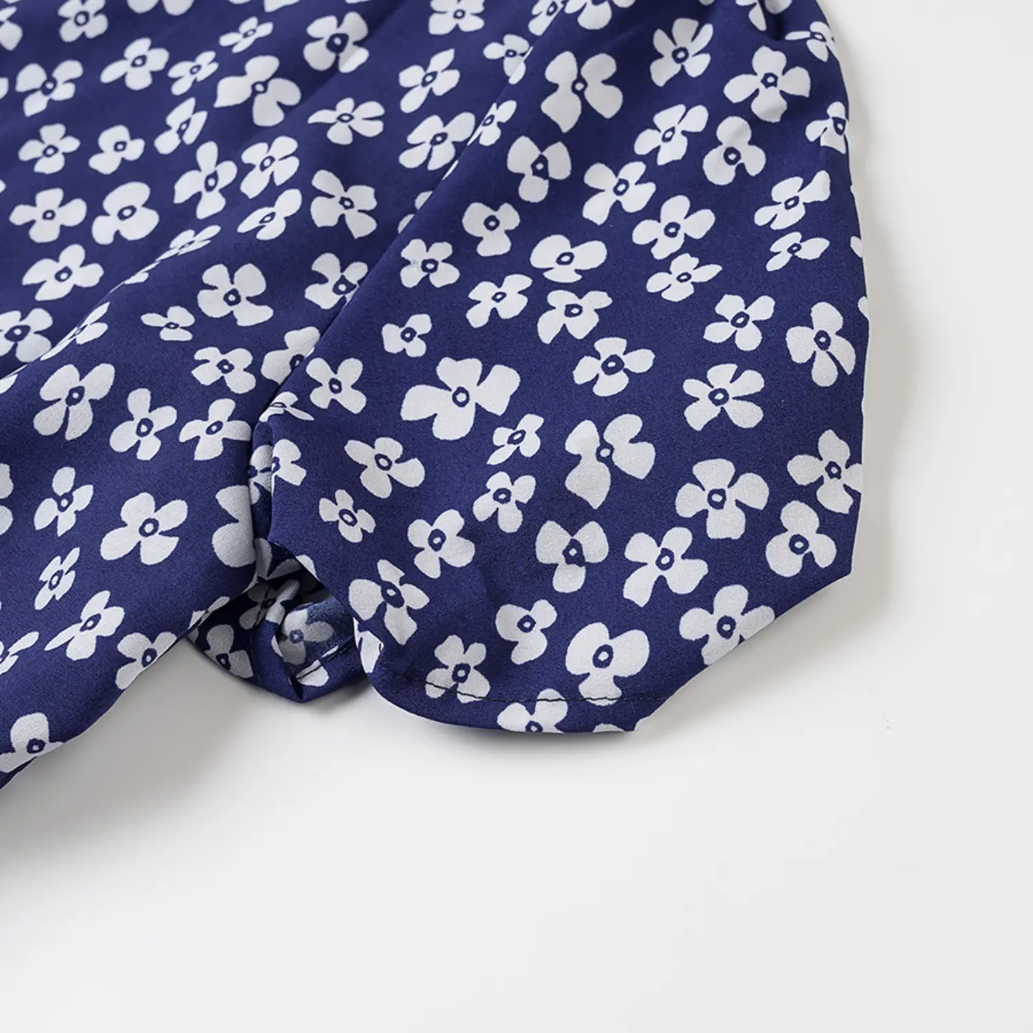 Close-up of the puff sleeve construction and finished cuff on the navy blue floral dress