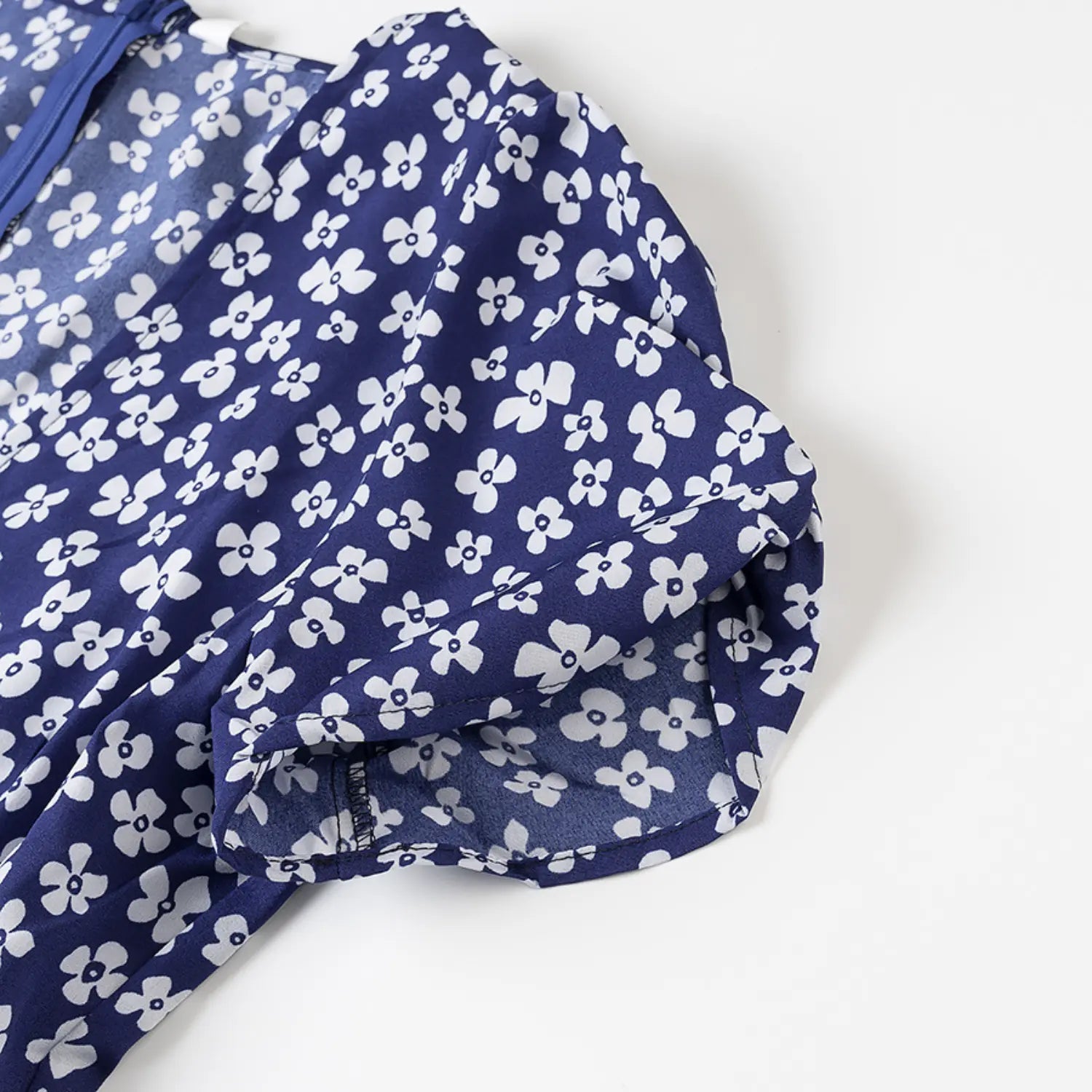 Close-up of the puff sleeve shoulder seam on the navy blue floral dress