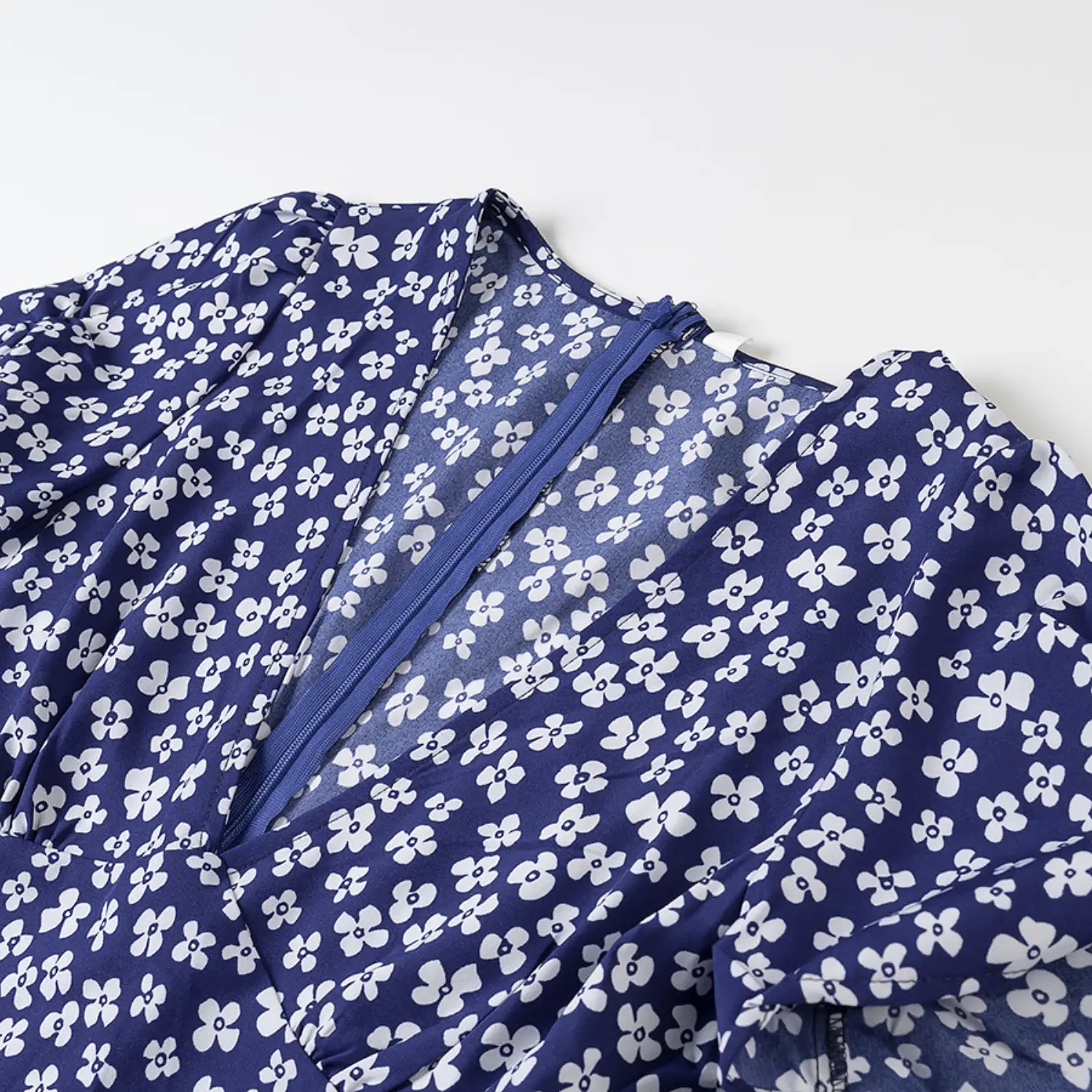 Close-up of the V-neckline and back zipper on the navy blue floral dress