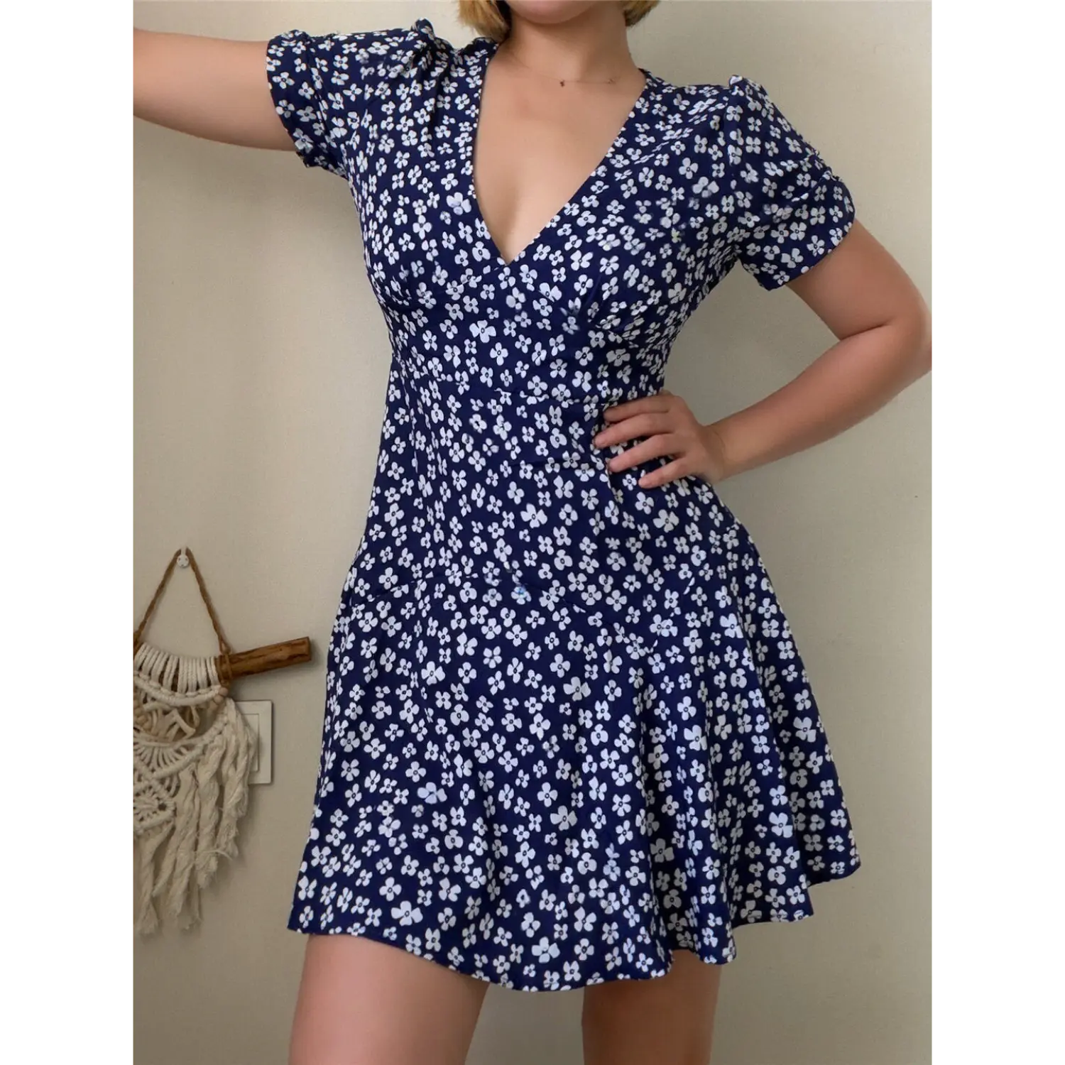 Close-up lifestyle shot of model wearing the navy blue floral puff-sleeve dress