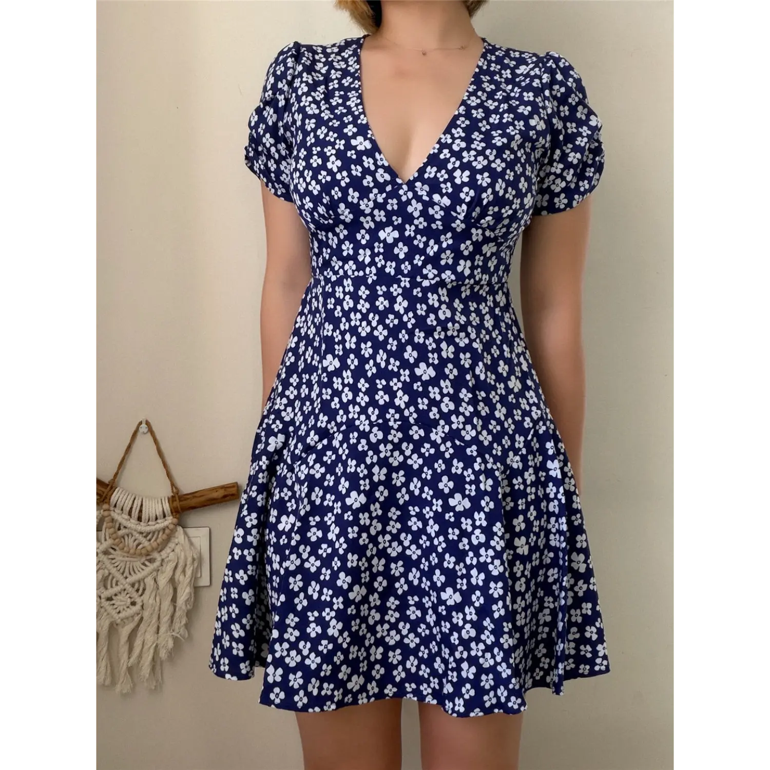 Lifestyle shot of model wearing the navy blue floral V-neck puff-sleeve mini dress