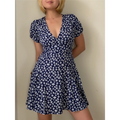 Lifestyle side shot of model wearing the navy blue floral V-neck dress