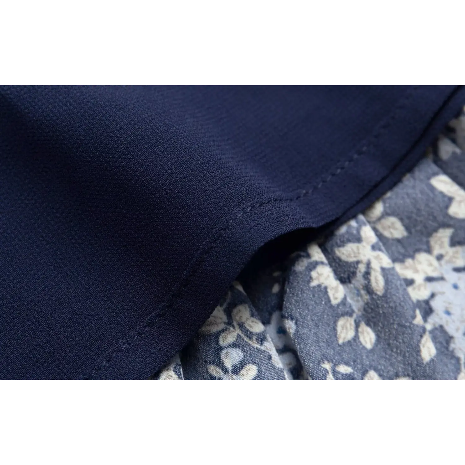 Close-up of the solid navy blue lining fabric of the floral dress