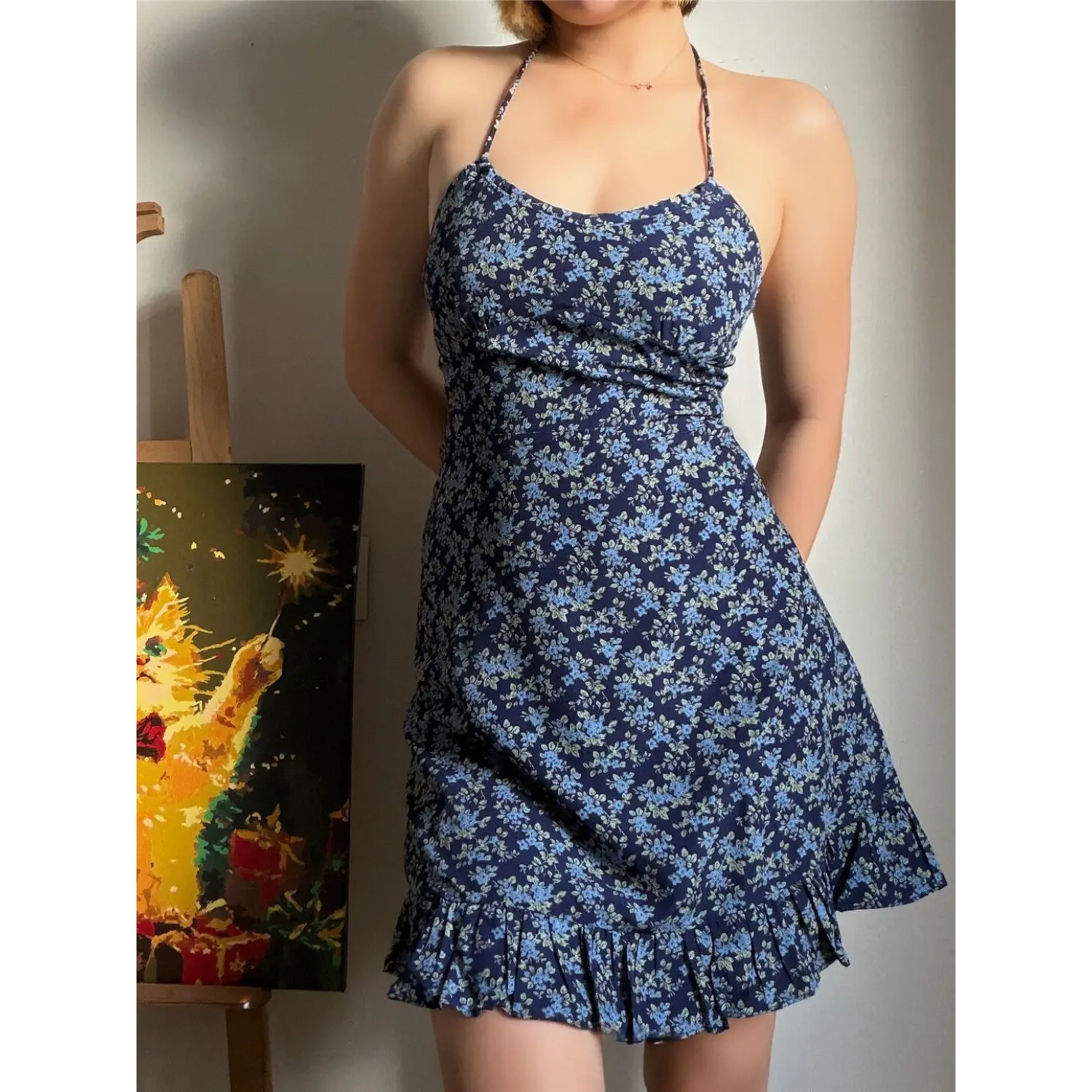  Lifestyle shot of model wearing the navy blue floral halter dress, showing the front silhouette