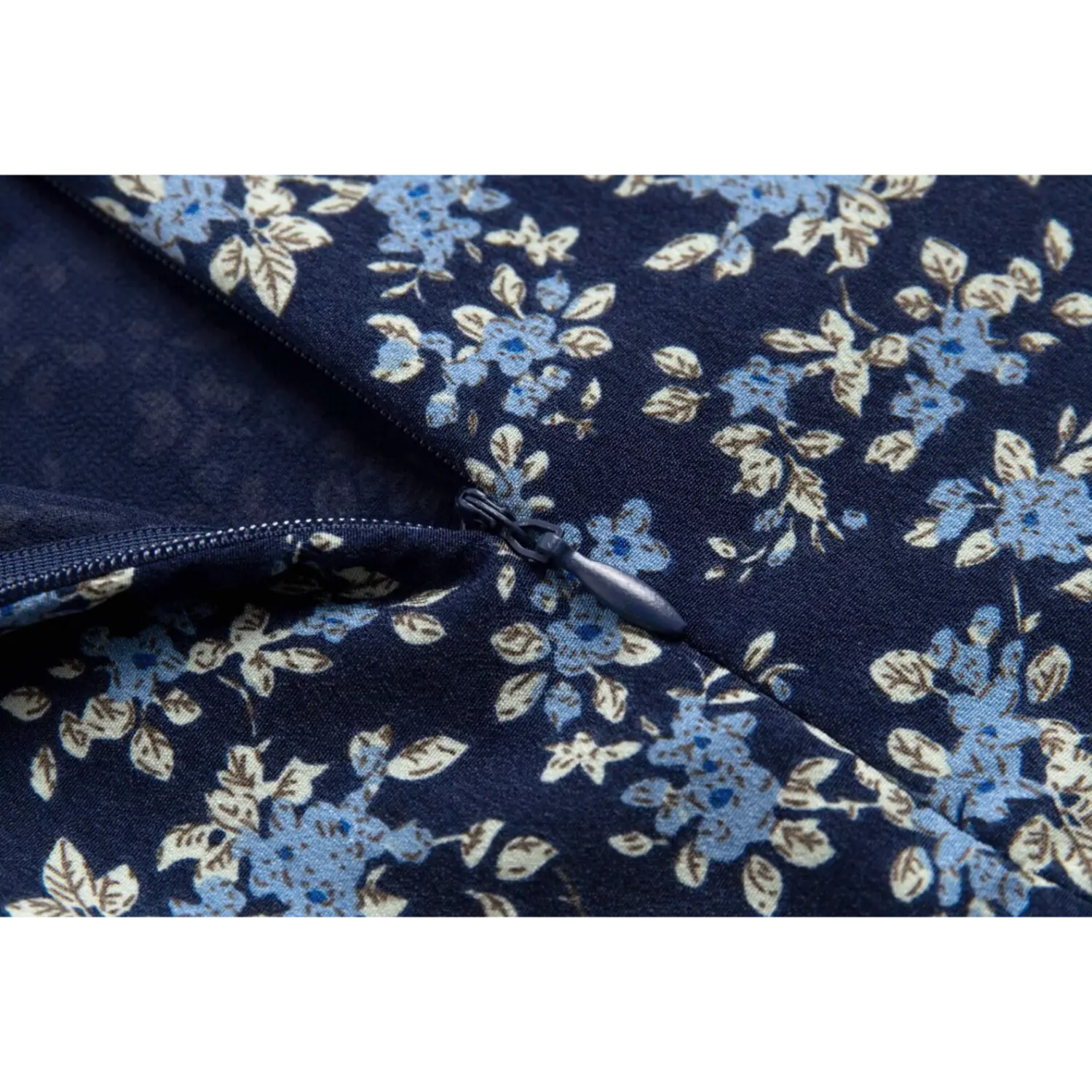 Close-up of the invisible side zipper on the navy blue floral spaghetti strap dress