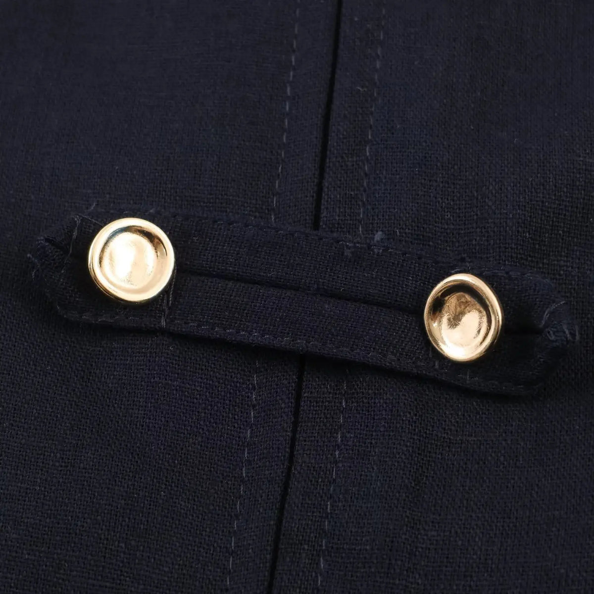 Macro shot of double gold metal buttons on navy halter mini dress decorative tab