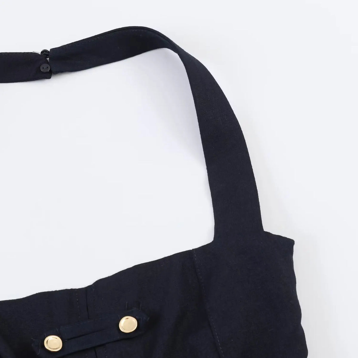 Partial shot of wide halter neck strap of navy mini dress, woven fabric stitching detail
