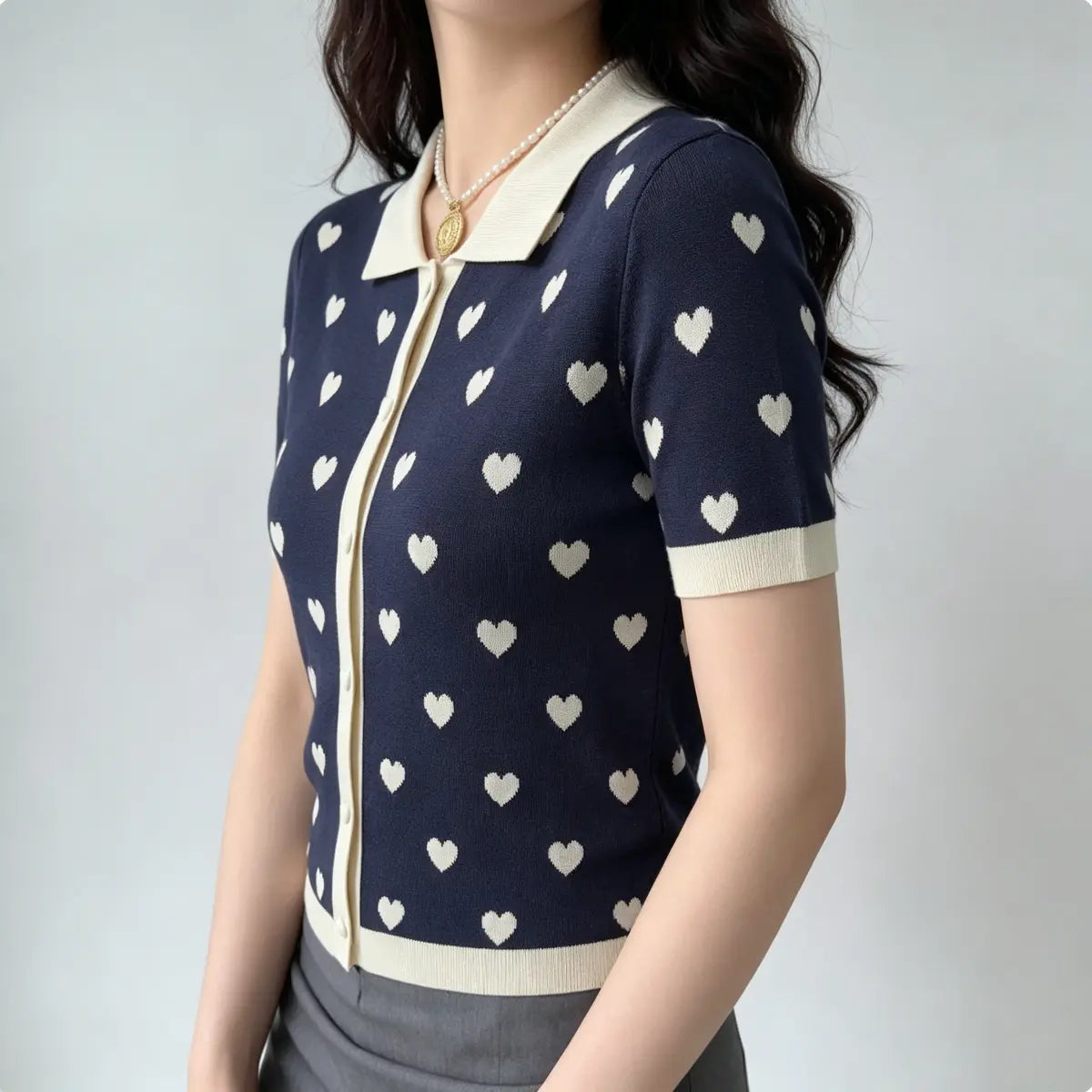 Side view of model in navy heart print knit polo cardigan, highlighting the cream contrast placket and hem.