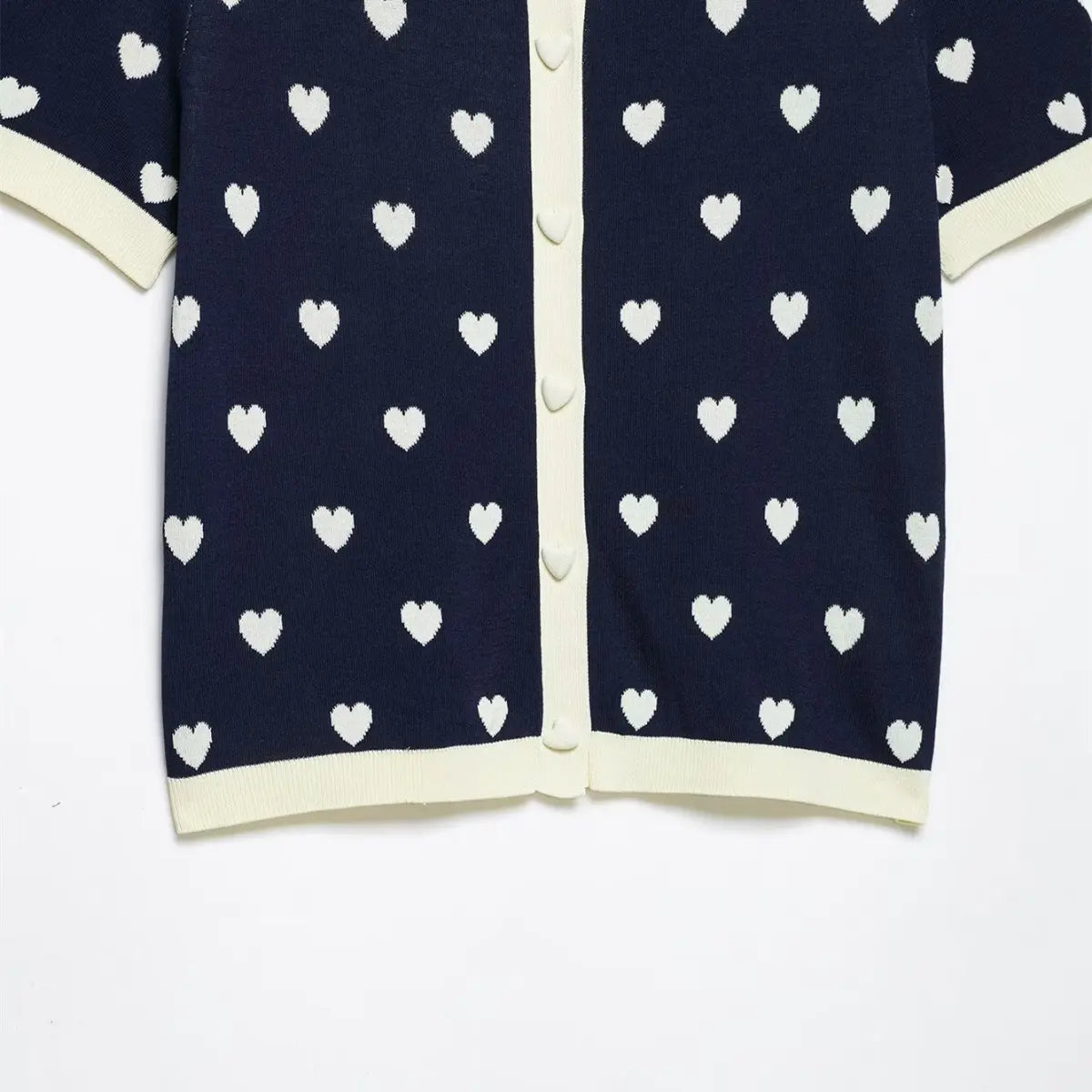 Full front view of navy heart print knit polo top, featuring contrast trim and heart-shaped buttons.