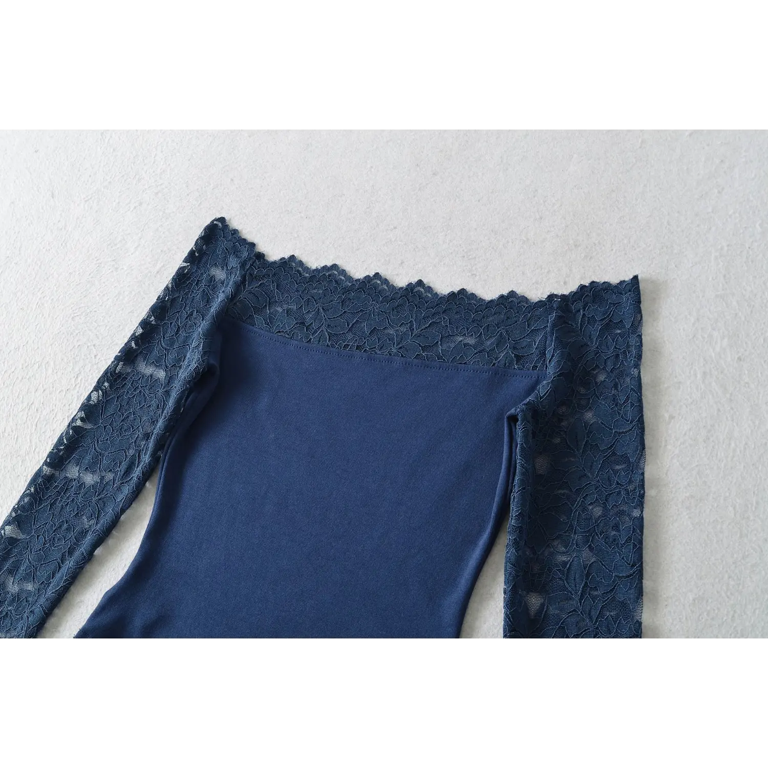 Flat view close‑up, navy blue off‑shoulder top showcasing scalloped floral lace off‑the‑shoulder neckline