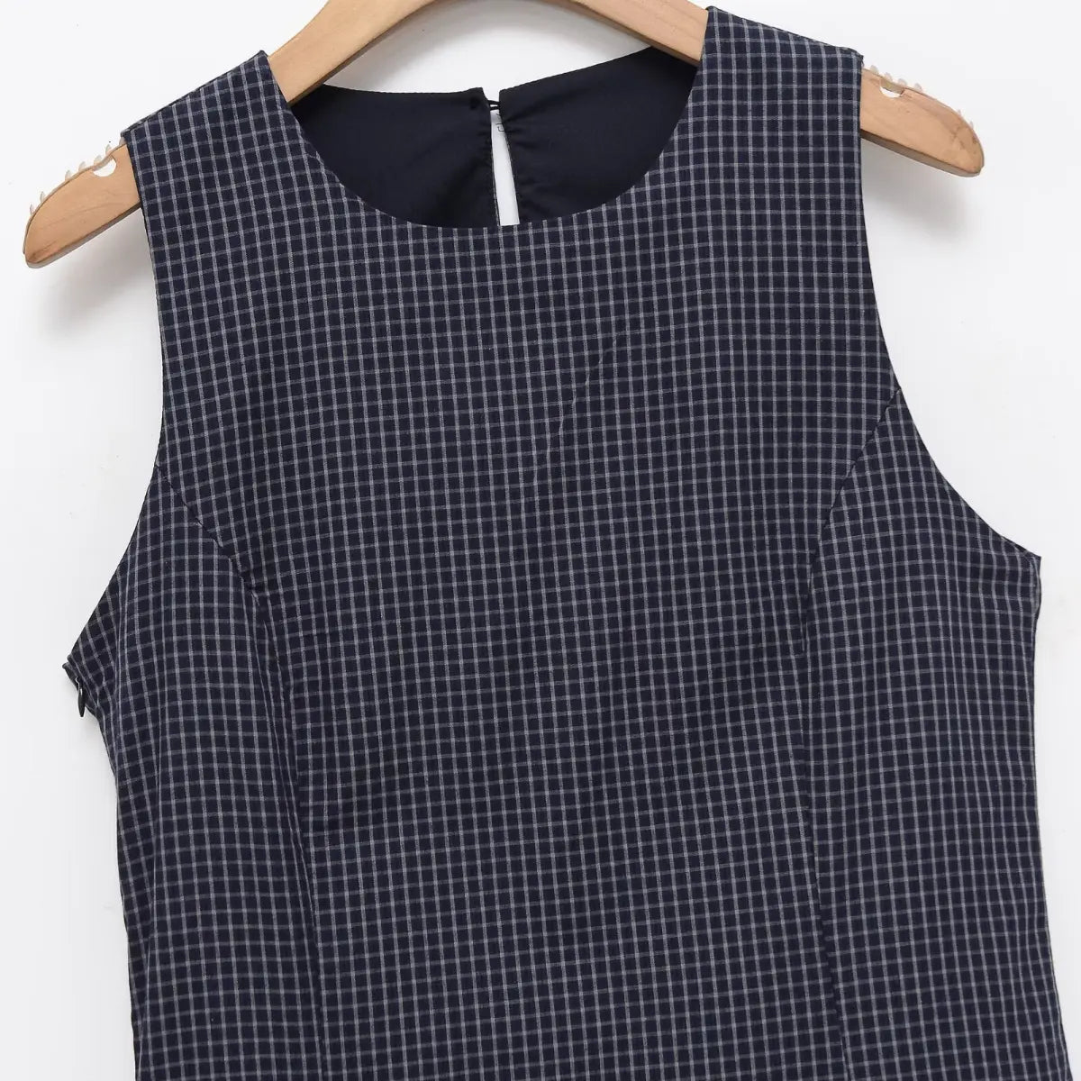 Front view of navy plaid sleeveless dress, showing round neckline and fitted bodice