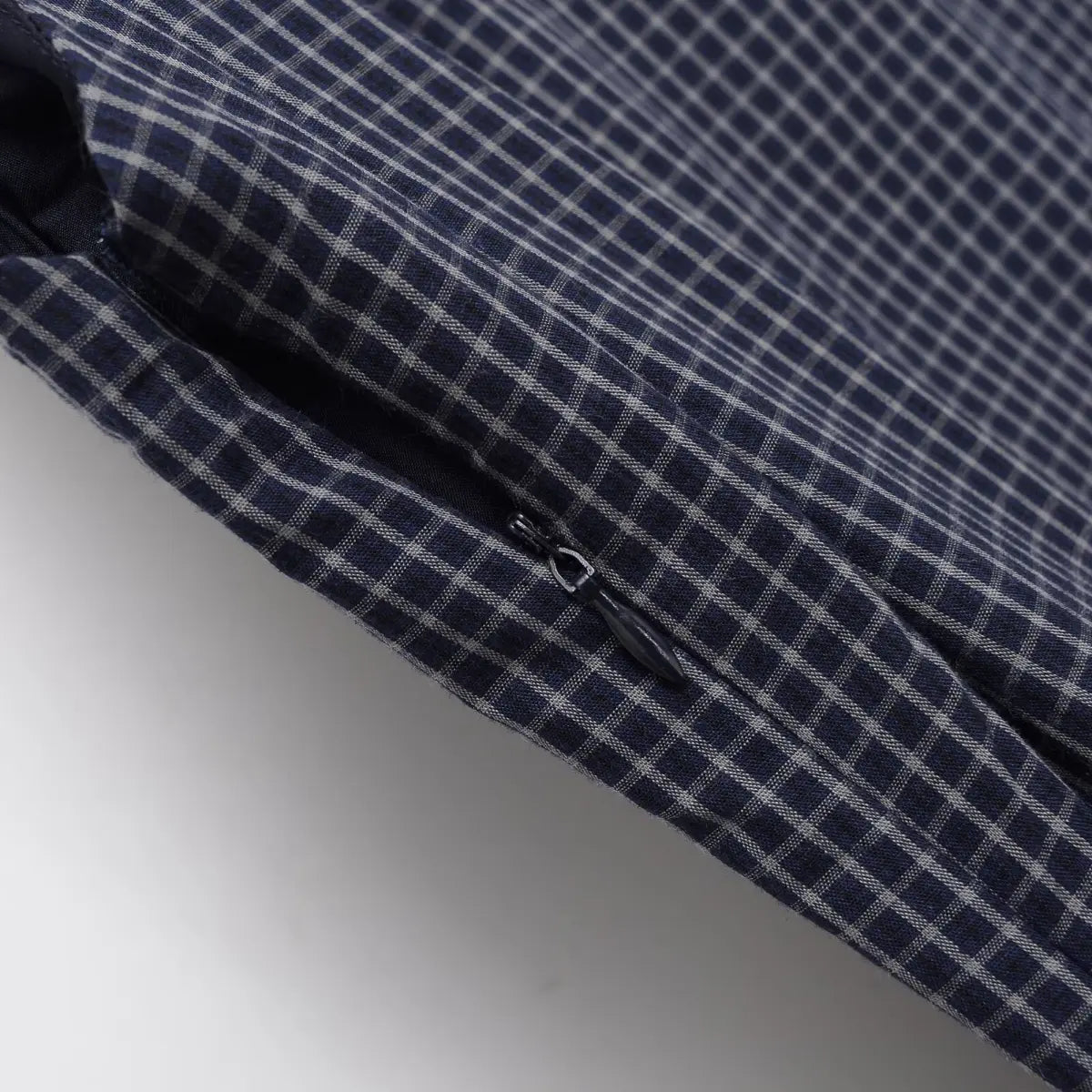 Close-up of the zipper pull on the navy plaid dress