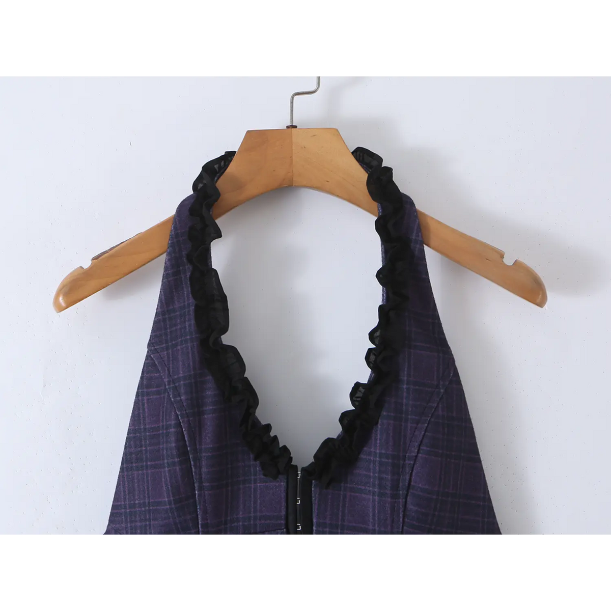Close-up of halter neckline with black chiffon ruffle trim on navy plaid mini dress