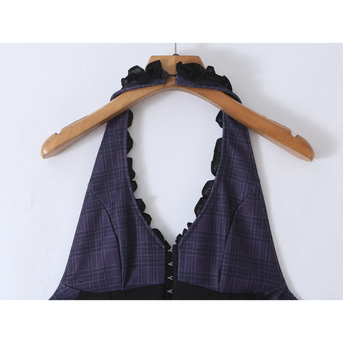 Close-up of halter V-neck with black chiffon ruffle trim on navy plaid mini dress