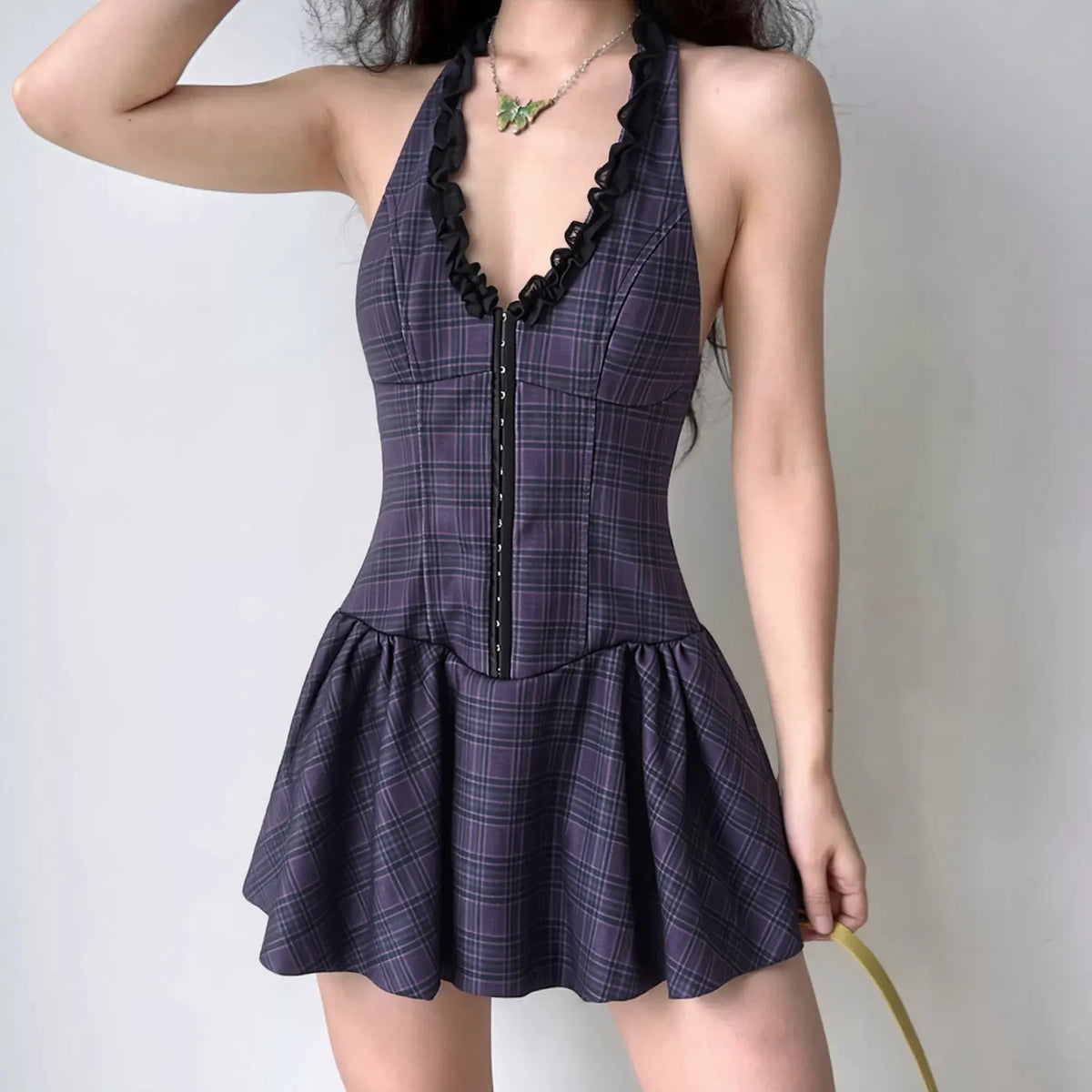 Model wearing navy plaid halter mini dress, front view, fitted corset bodice and flared skater skirt