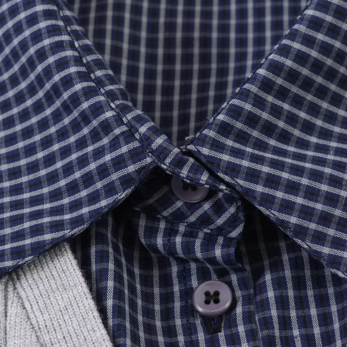 Close-up of the navy plaid shirt collar and purple buttons