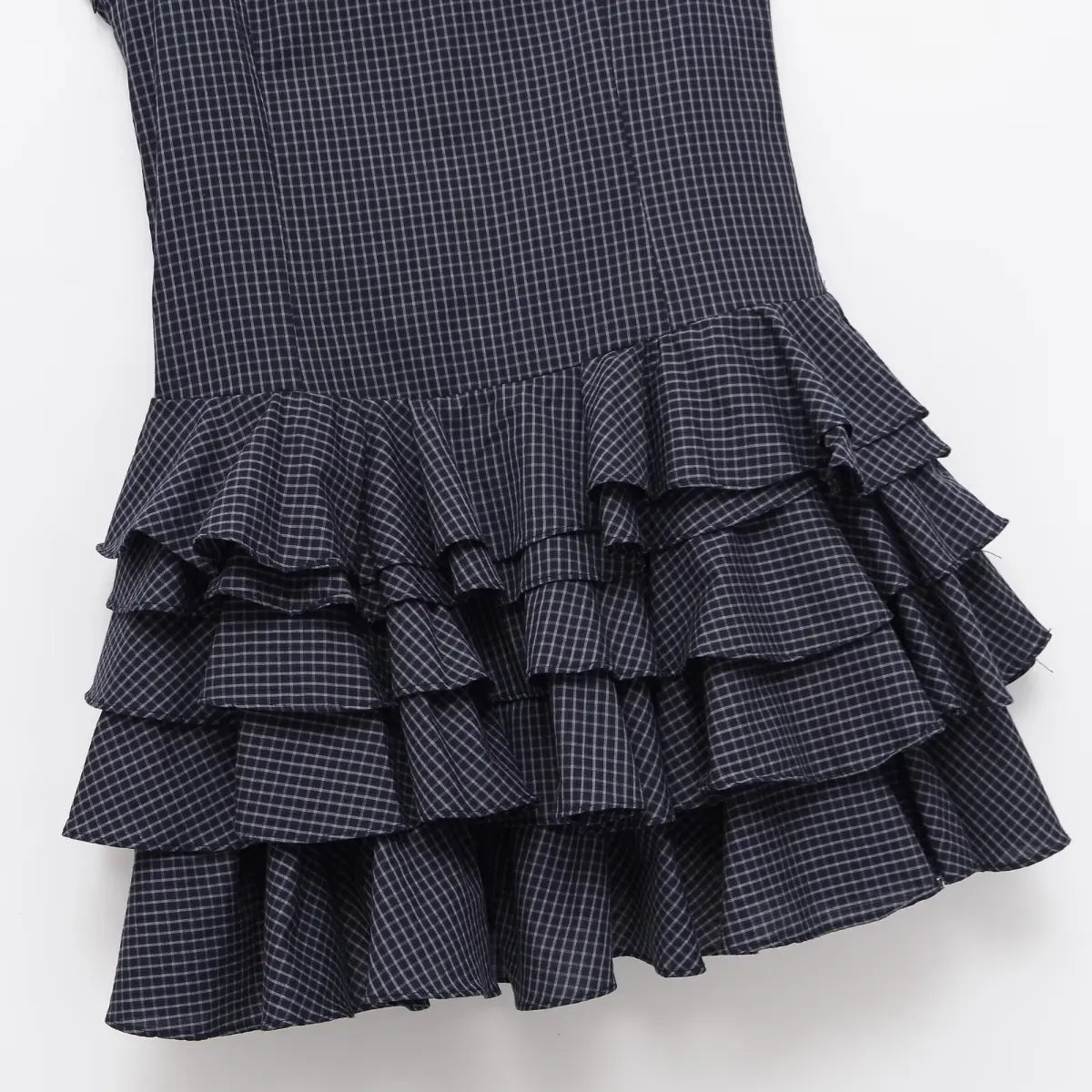 Hem detail of navy plaid dress, showing the tiered ruffle skirt layers
