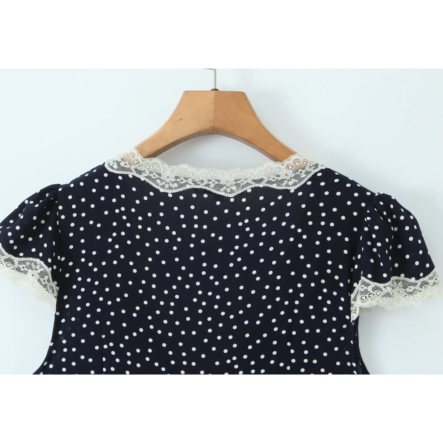 Navy polka dot mini dress back eyelash lace crew neck puff sleeve macro close-up, all-over uniform small dot print full white lash lace binding on cuffs & back neck neat serging seam craft shot