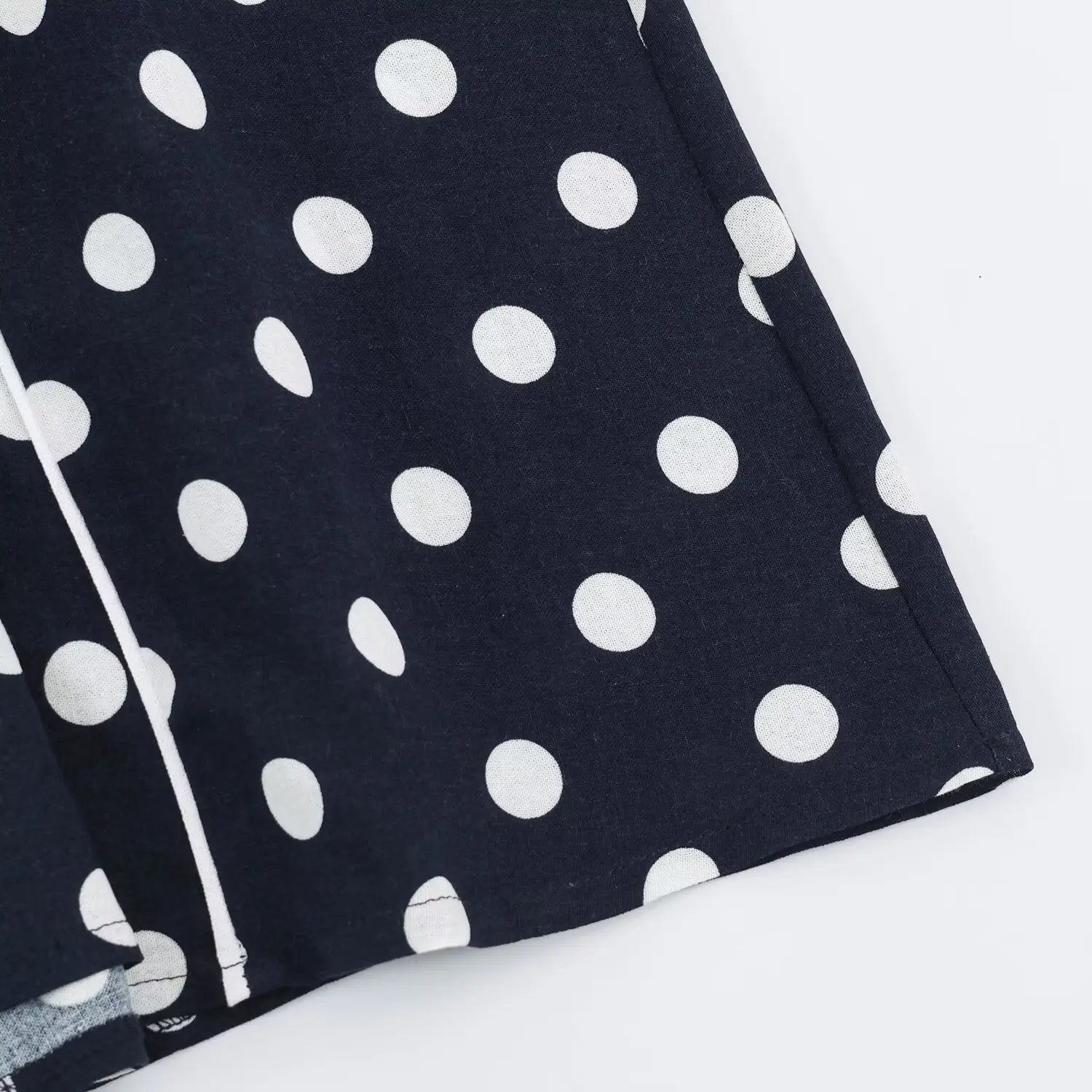 Close‑up of finished long skirt hem, woven polka dot fabric, neat seam stitching detail