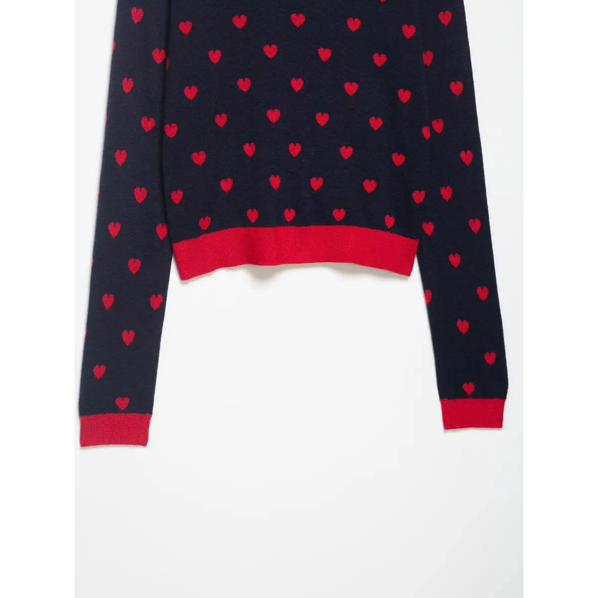 back view of a navy and red heart-patterned knit sweater with red cuffs and hem.