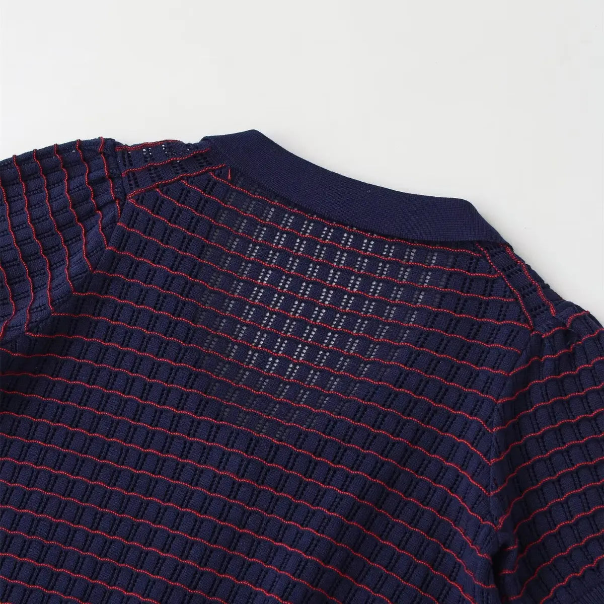 Back view of navy and red striped knit cardigan, highlighting the openwork pattern and polo collar