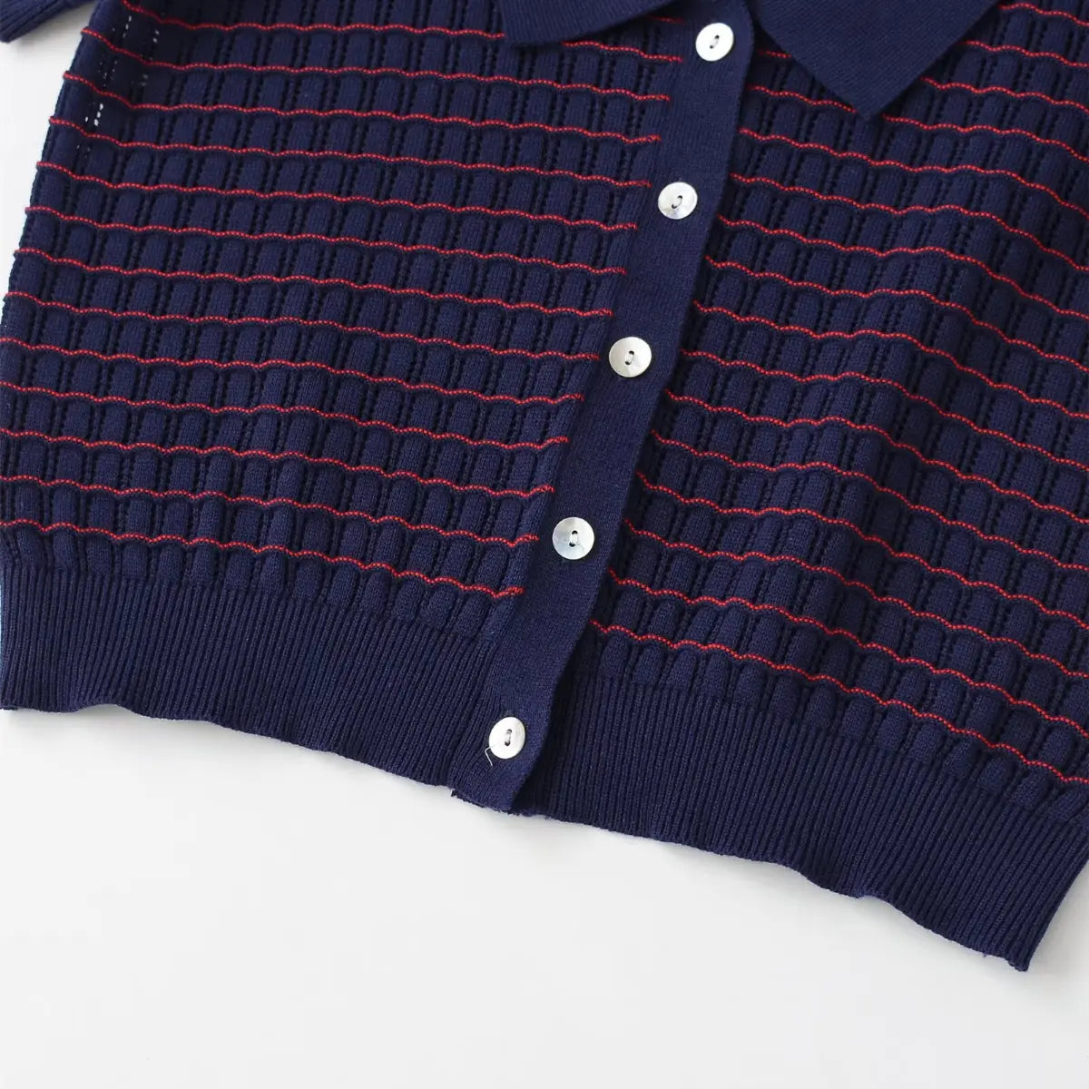 Full view of the button placket on the navy and red striped knit cardigan, showing the row of mother-of-pearl buttons
