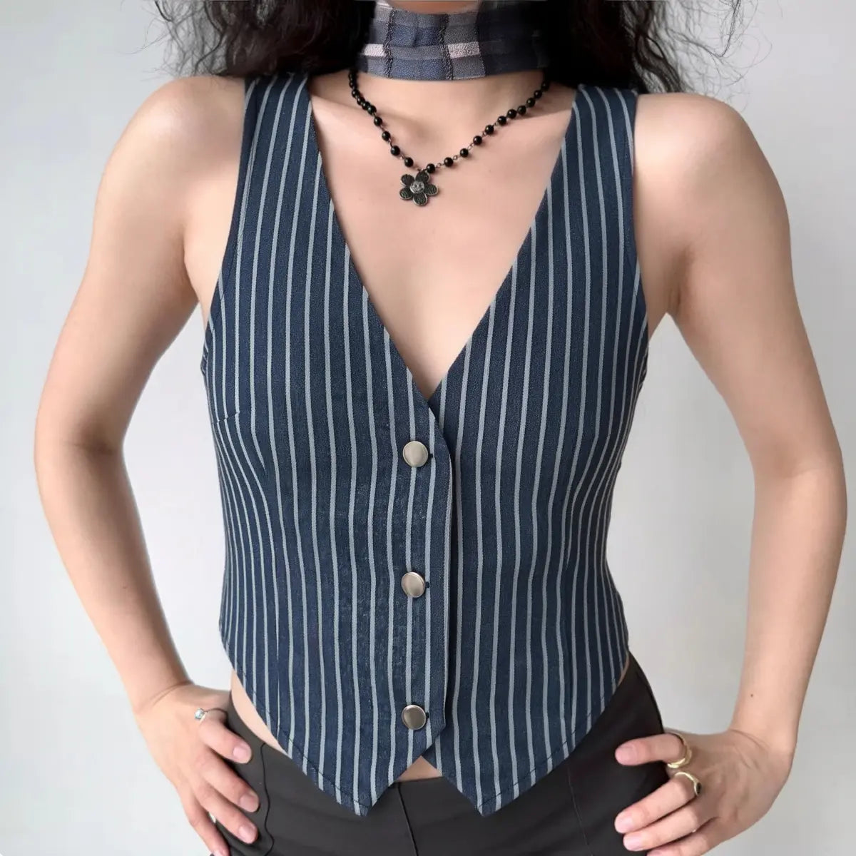 The vest styled on a model, highlighting its fitted silhouette and pointed hem.