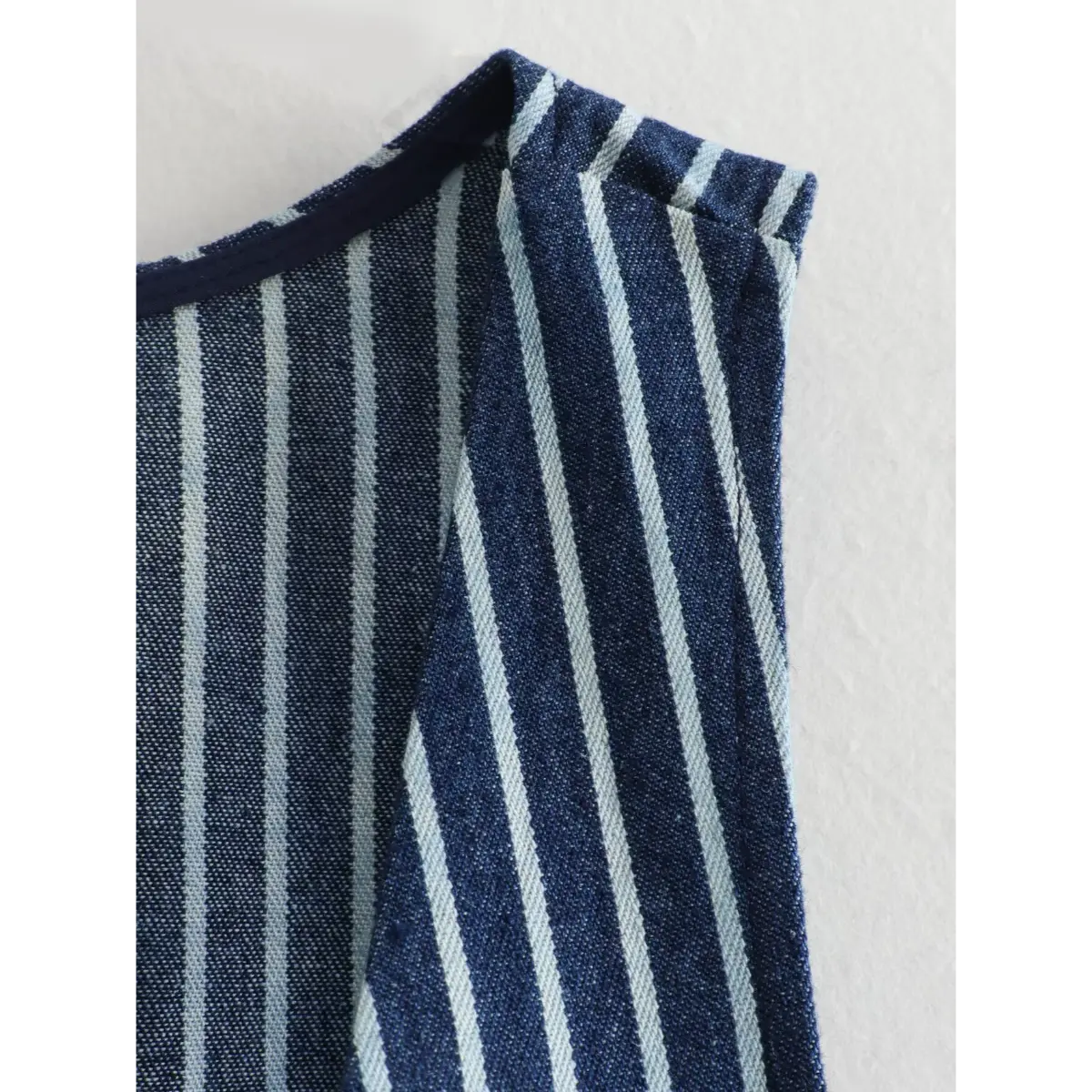 Close-up of the vest's armhole and neckline construction.