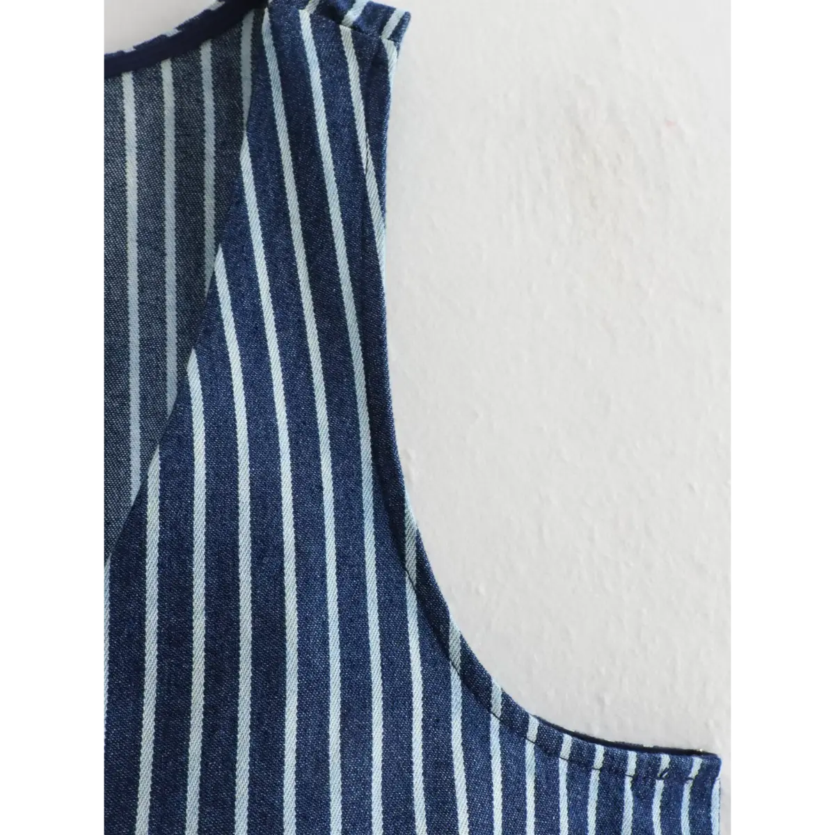 Close-up of the vest's side armhole and V-neck edge.
