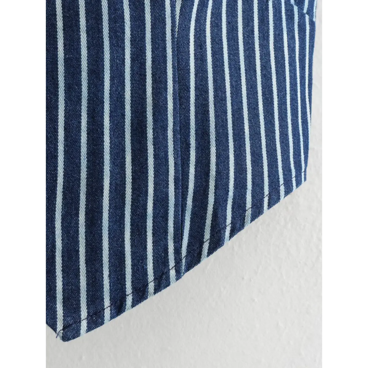 Close-up of the vest's side hem and stitching.