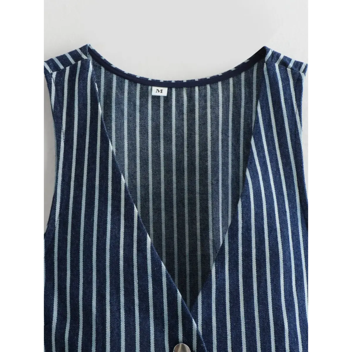 Close-up of the vest's V-neckline, showing the inner label and lining.