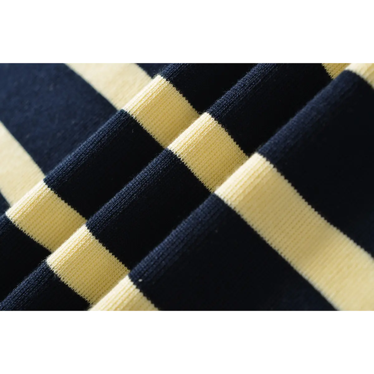 Close-up detail of the ribbed knit fabric on a navy and pale yellow striped maxi dress.