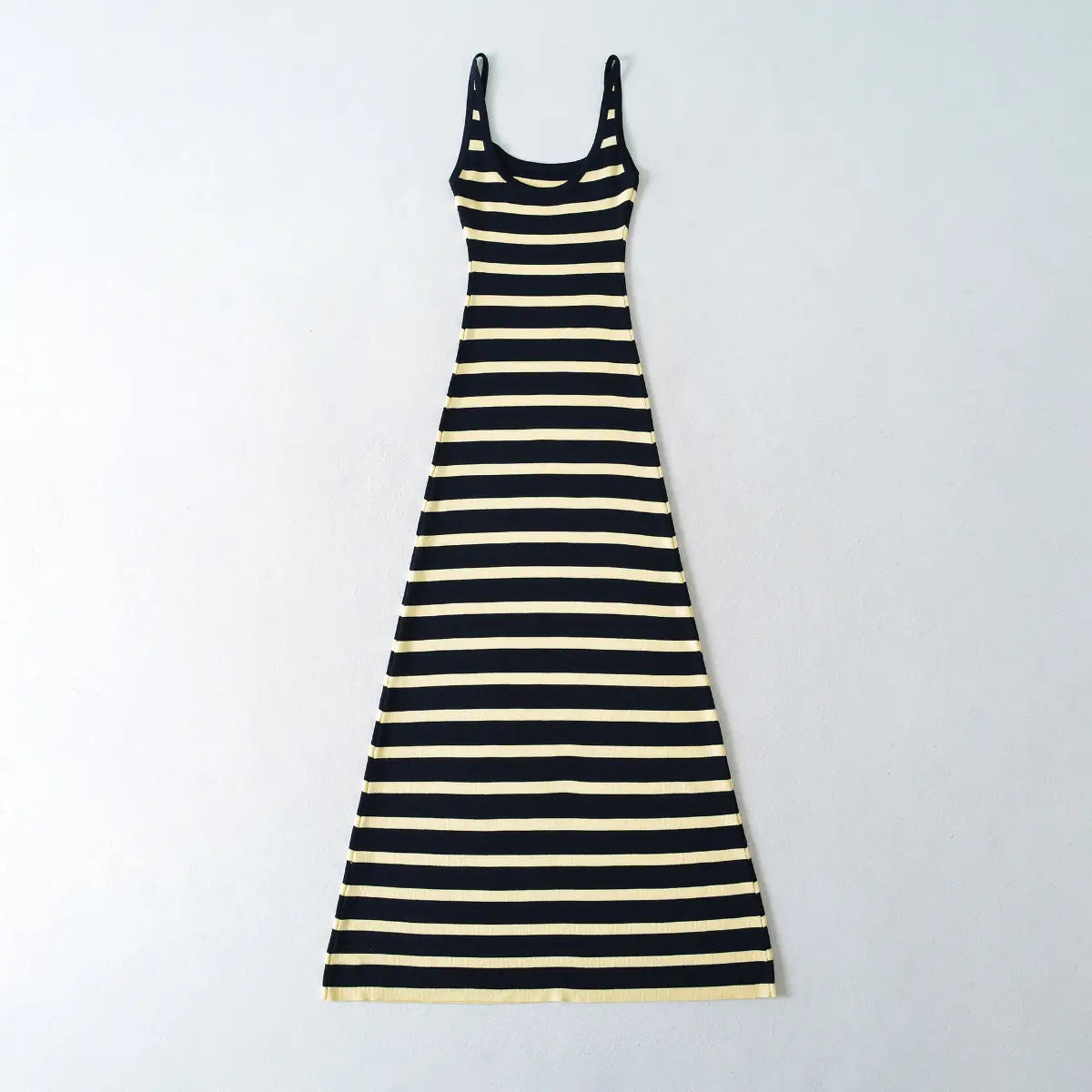 Flat lay view of a navy and pale yellow striped ribbed knit maxi dress, showing the full form-fitting silhouette.